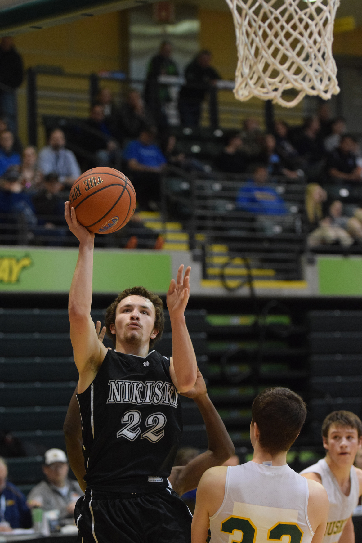 Nikiski senior guard Nathan Carstens drives to the paint against Delta Junction defenders Martese Blankenship (2) and Jean Gonzalez (20) Friday in the Class 3A boys state consolation semifinals at the Alaska Airlines Center in Anchorage.