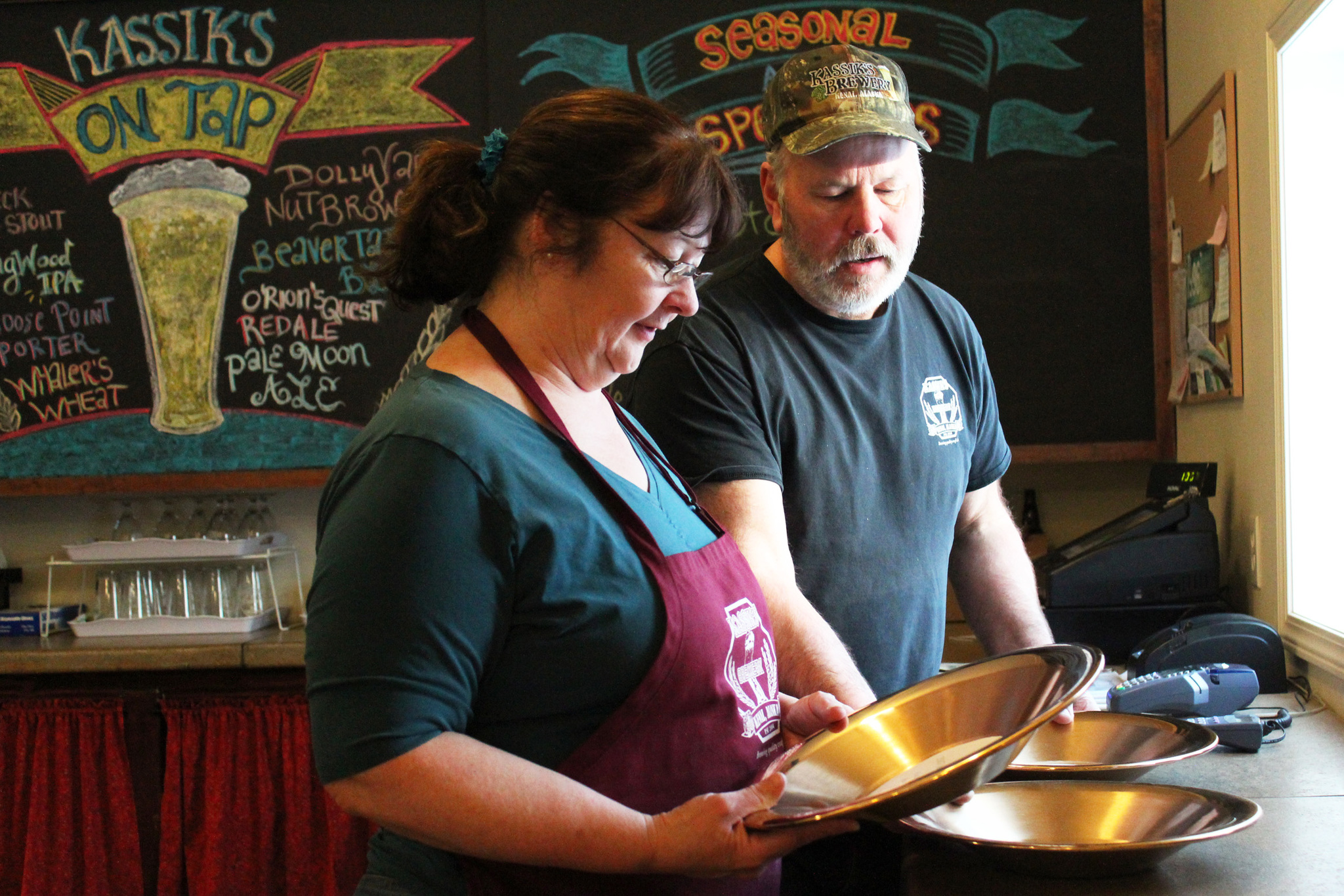 Debara and Frank Kassik inspect their new awards from the 2017 Great Alaska Beer and Barley Wine Festival alongside their award from the same festival last year Wednesday, Jan. 25, 2017 at Kassik’s Brewery in North Kenai, Alaska. The couple won 1st place this year for their Buffalo Head Barley Wine, and 1st place in the winter seasonal category for their Barrel Aged Statny Statny. (Megan Pacer/Peninsula Clarion)