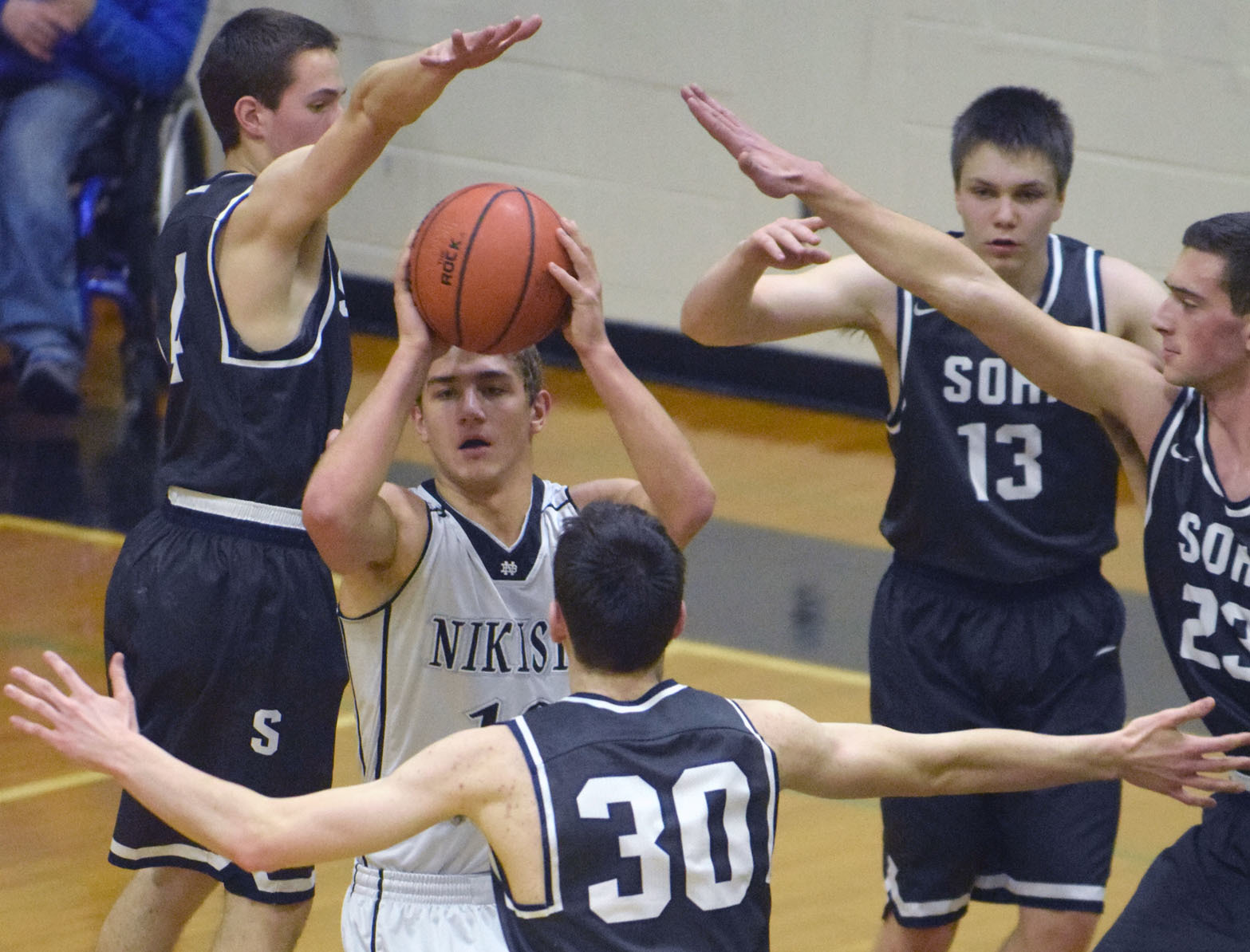 Nikiski’s Ian Johnson extracts himself from a maze of defenders Tuesday, Jan. 31, 2017, at Nikiski High School. From left are Caleb Spence, Sam McElroy, Eli Sheridan and Derek Evans. (Photo by Jeff Helminiak/Peninsula Clarion)