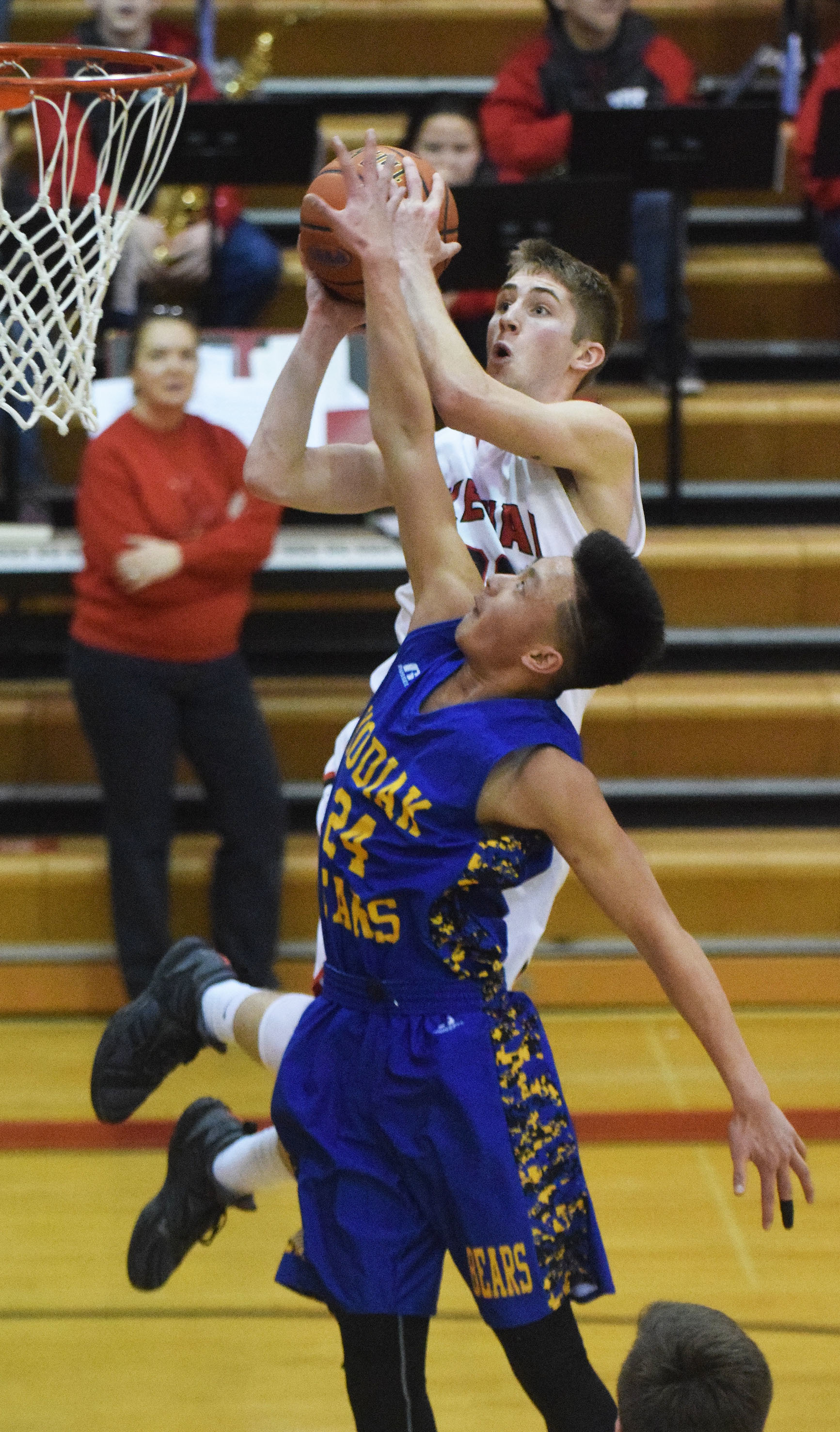 Kenai Central’s Josh Jackman lays in a shot over Kodiak defender Roberto Giron, Friday night at Kenai Central High School. (Photo by Joey Klecka/Peninsula Clarion)