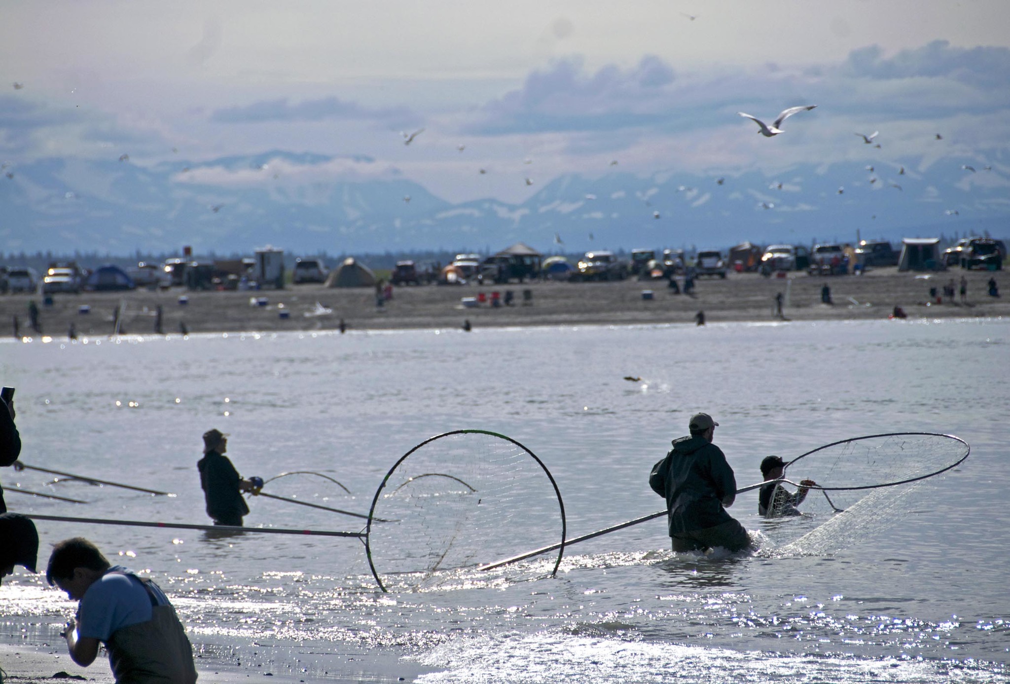 In this July 2016 photo, dipnetters make their way out into the water at the mouth of the Kenai River during the annual personal use dipnet fishery in Kenai, Alaska. (Elizabeth Earl/Peninsula Clarion, file)