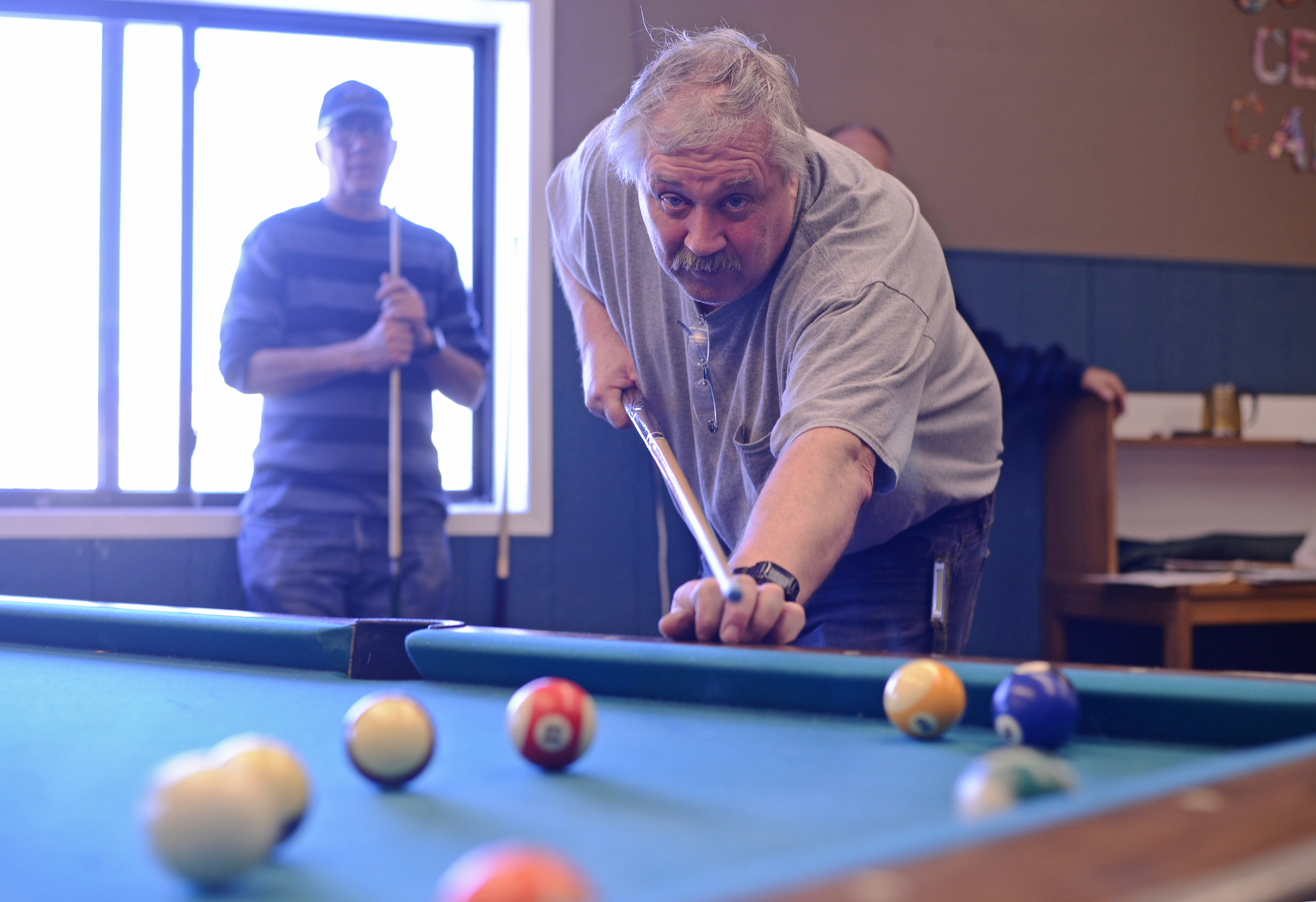 In the final game of the Kenai Senior Olympics pool tournament, Max Pitts watches his shot while his opponent, last year’s champion Ken Losser, rests in the background on Tuesday, Feb. 21, 2017 at the Kenai Teen Center in Kenai, Alaska. Losser won, remaining undefeated in this year’s 8-player double elimination competion, though narrowly — Pitts scratched on the eight ball. The 13th annual Senior Olympics will continue until Saturday with events including poker, pinochle, ping-pong, darts, dominoes, cribbage, basketball, and Wii bowling. (Ben Boettger/Peninsula Clarion)