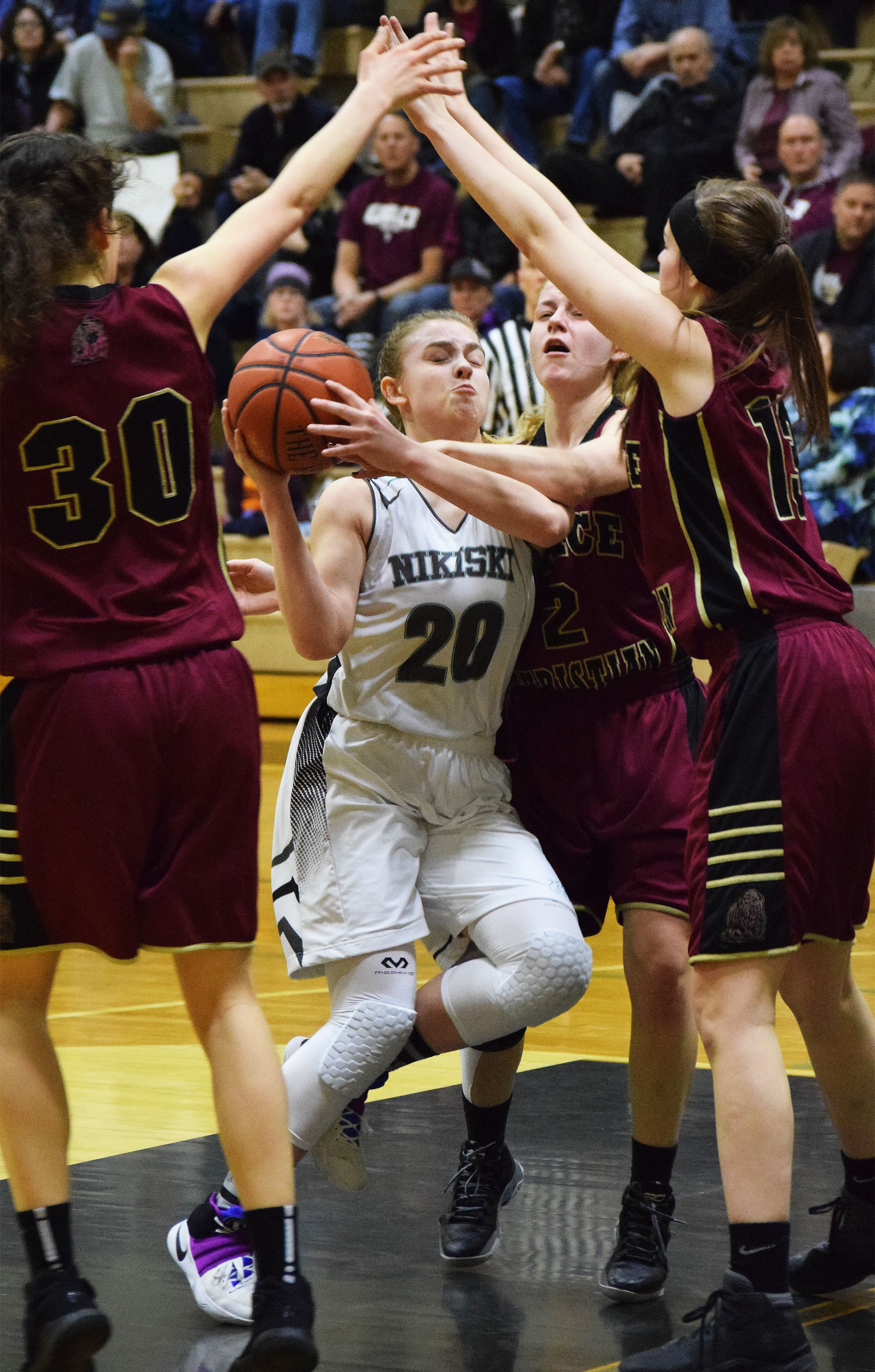 Nikiski guard Bethany Carstens (20) works to find a way through a horde of Grace Christian defenders Friday night at Nikiski High School. (Photo by Joey Klecka/Peninsula Clarion)