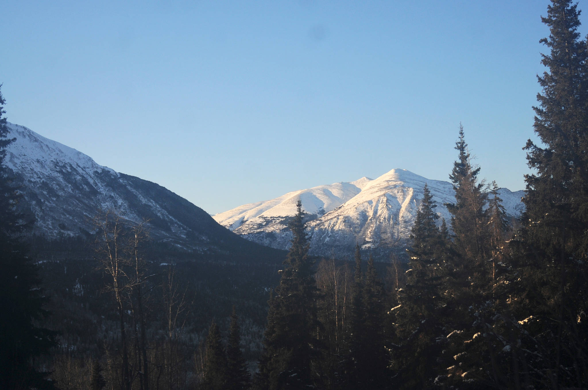 Sunlight shines on the snow-capped mountains in this photo taken in February on Resurrection Pass Trail in Cooper Landing, Alaska. (Elizabeth Earl/Peninsula Clarion)