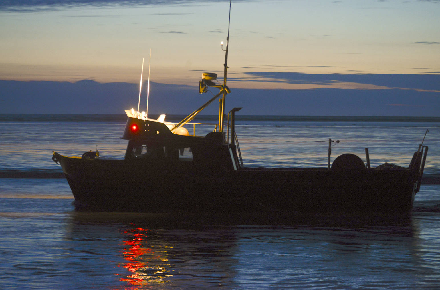 A commercial drift gillnetting boat leaves the mouth of the Kasilof River at about 1 a.m. July 17, 2014 during an overnight fishing period in Kasilof, Alaska. (Clarion file photo)