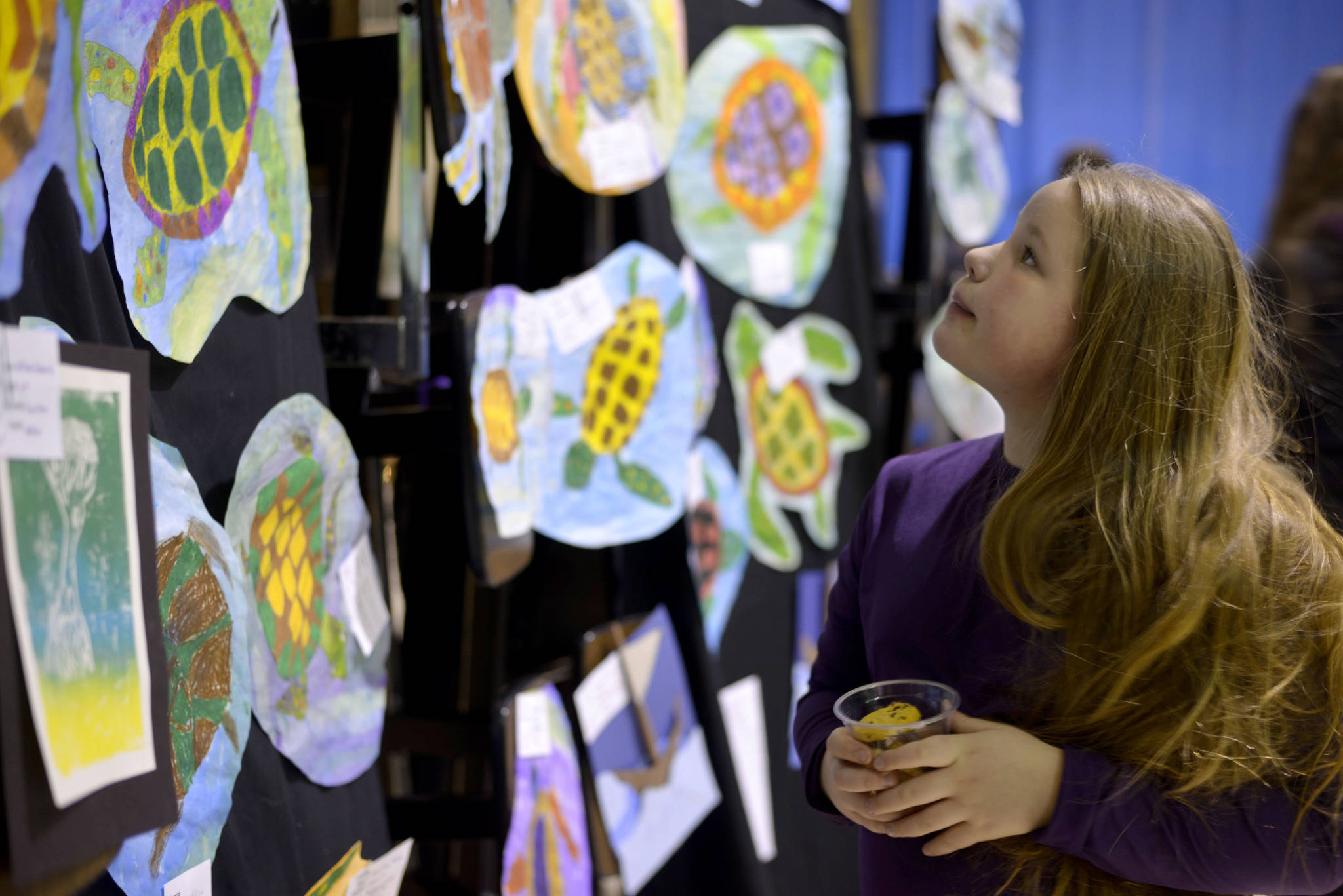 Shelby Moore, 9, went through the rows of art created by her fellow Mountain View Elementary School students at an “Evening of Art” on Thursday, March 2. She stopped to look more closely at the oil pastel turtles created by fifth-graders.