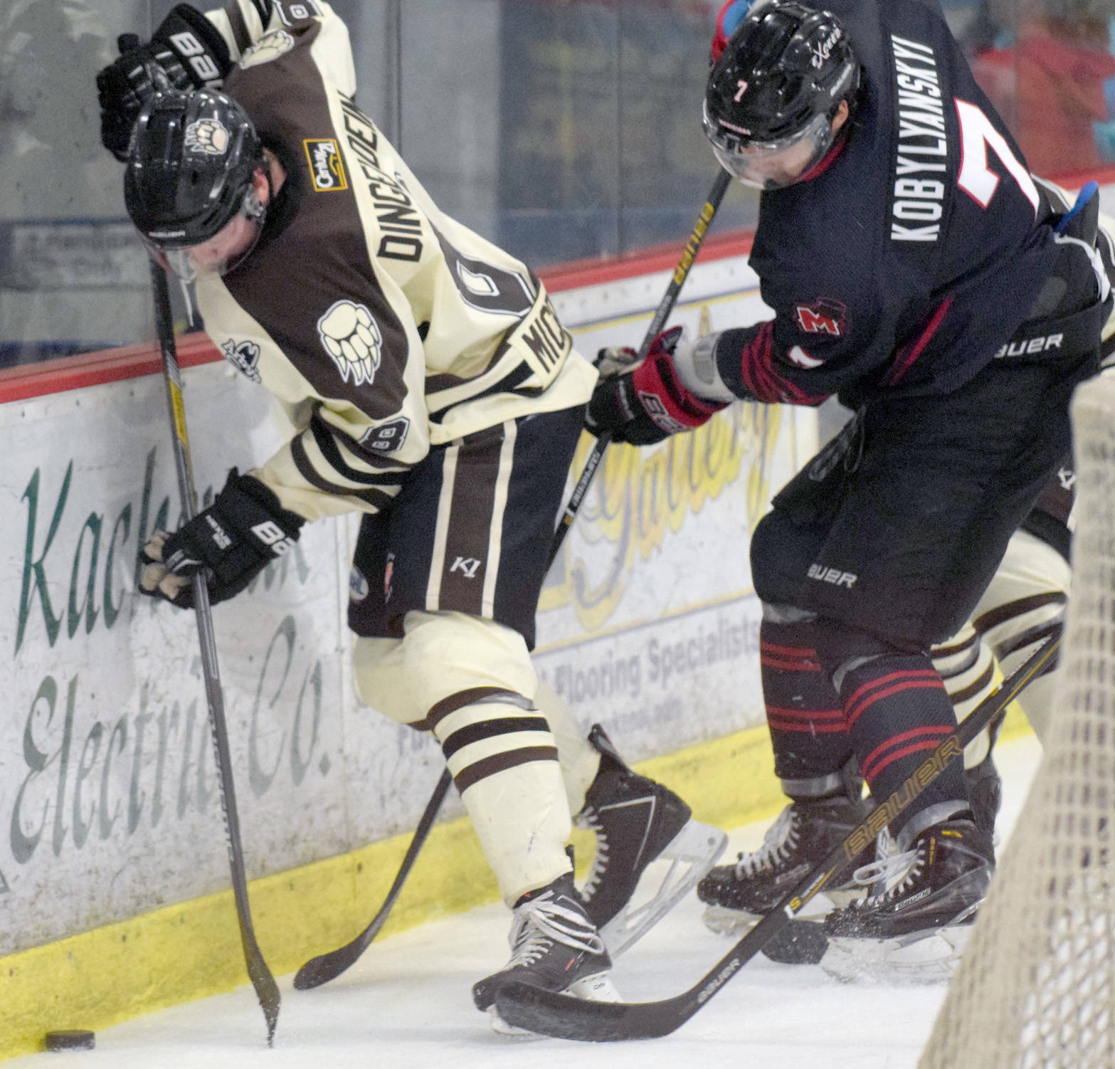 Kenai River defenseman Alex Dingeldein and Minnesota forward Dmytro Kobylyanskyi battle for the puck behind the net Friday, March 3, 2017, at the Soldotna Regional Sports Complex. (Photo by Jeff Helminiak/Peninsula Clarion)