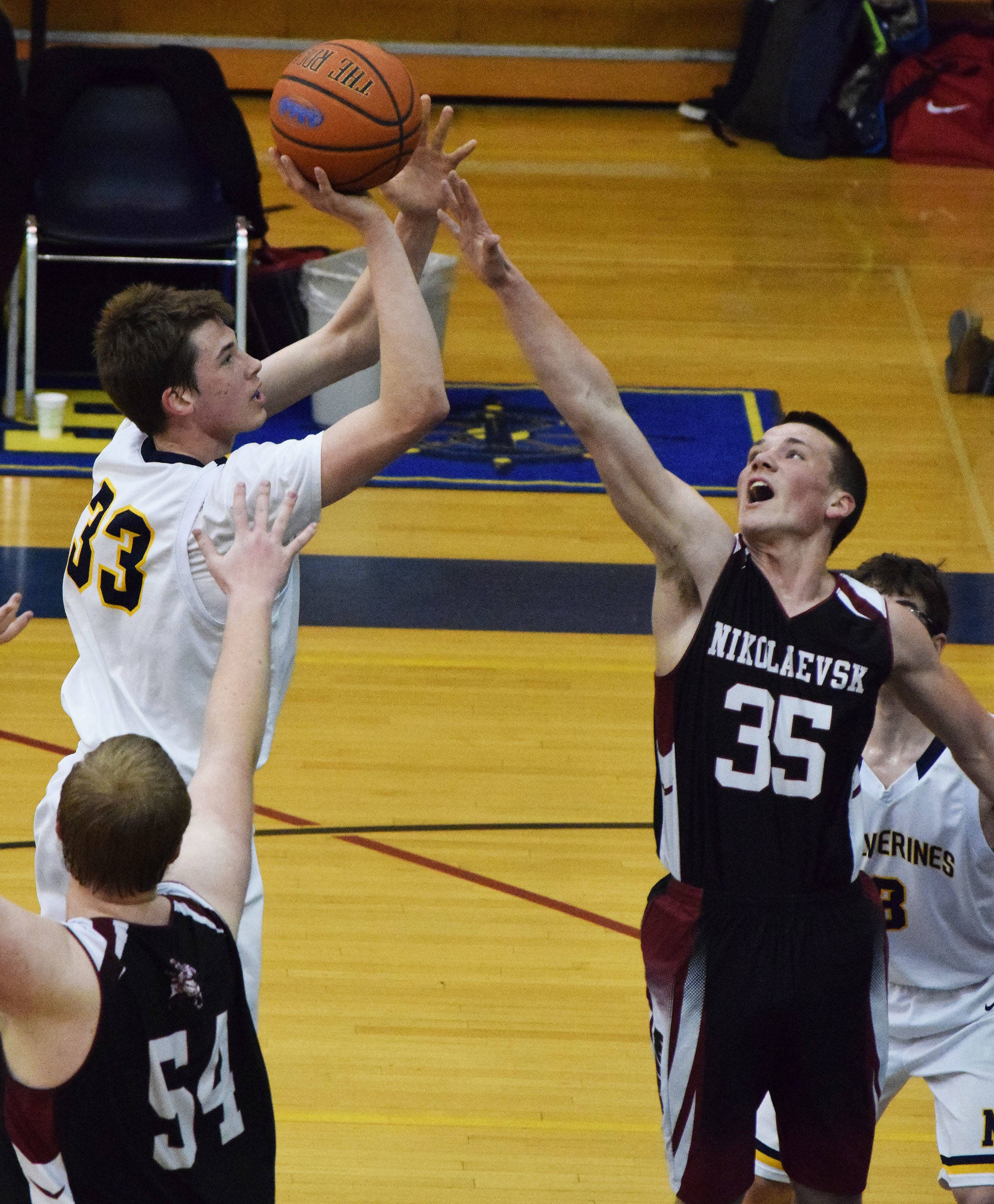 Nikolaevsk’s Zachary Trail (35) puts a hand up on NInilchik’s Austin White in Friday’s Peninsula Conference boys championship game at Homer High School. (Photo by Joey Klecka/Peninsula Clarion)