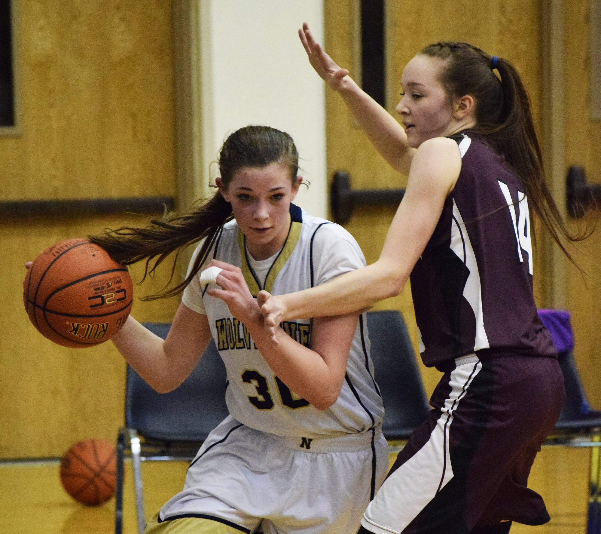 Ninilchik’s DeeAnn White (left) looks for space against Nikolaevsk’s Elizabeth Fefelov in the second half of Friday’s Peninsula Conference girls championship game at Homer High School. (Photo by Joey Klecka/Peninsula Clarion)