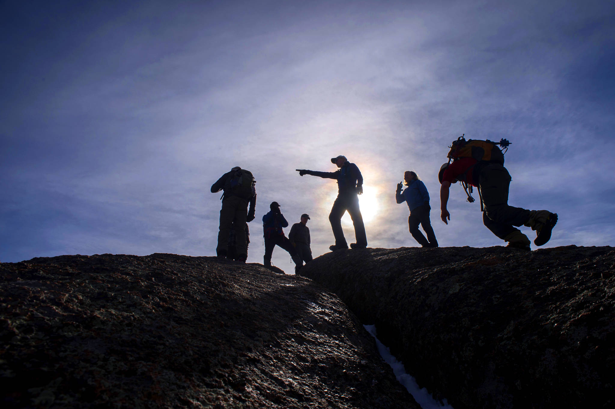 Tony Eichstadt, pointing, and the dozen mountaineers climbing with Eric Swab Tuesday, Jan. 31, 2017, scramble to the summit of Cap Rock near Palmer Lake, Colo., while on their weekly trek exploring the remote and historic spots in the backcountry of the Pikes Peak region. (Christian Murdock/The Gazette via AP)