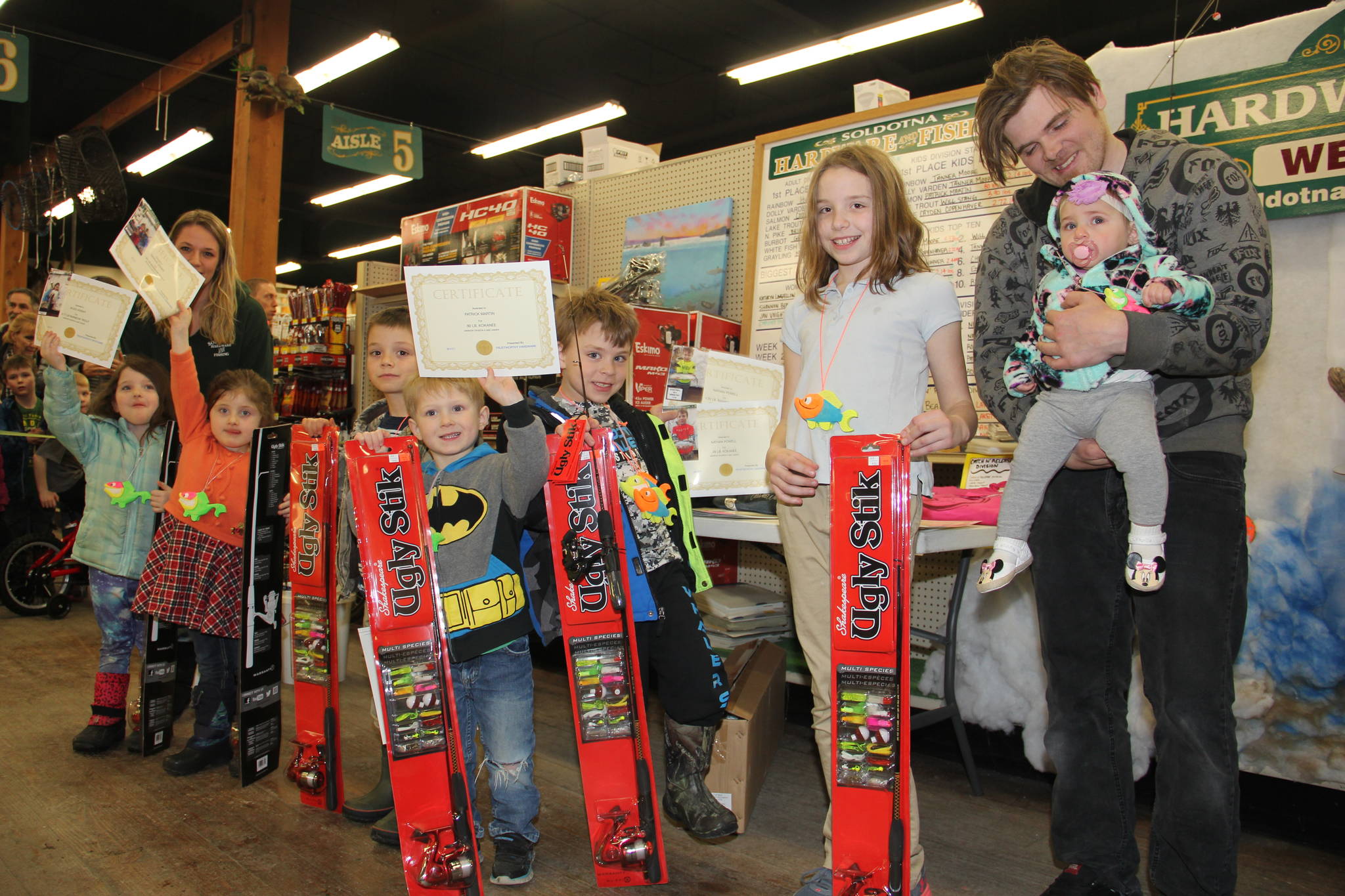 Ice Fishing Derby kid’s division winners claim prizes at awards ceremony, including 8-month-old Ariel Voight, the Derby’s youngest participant.