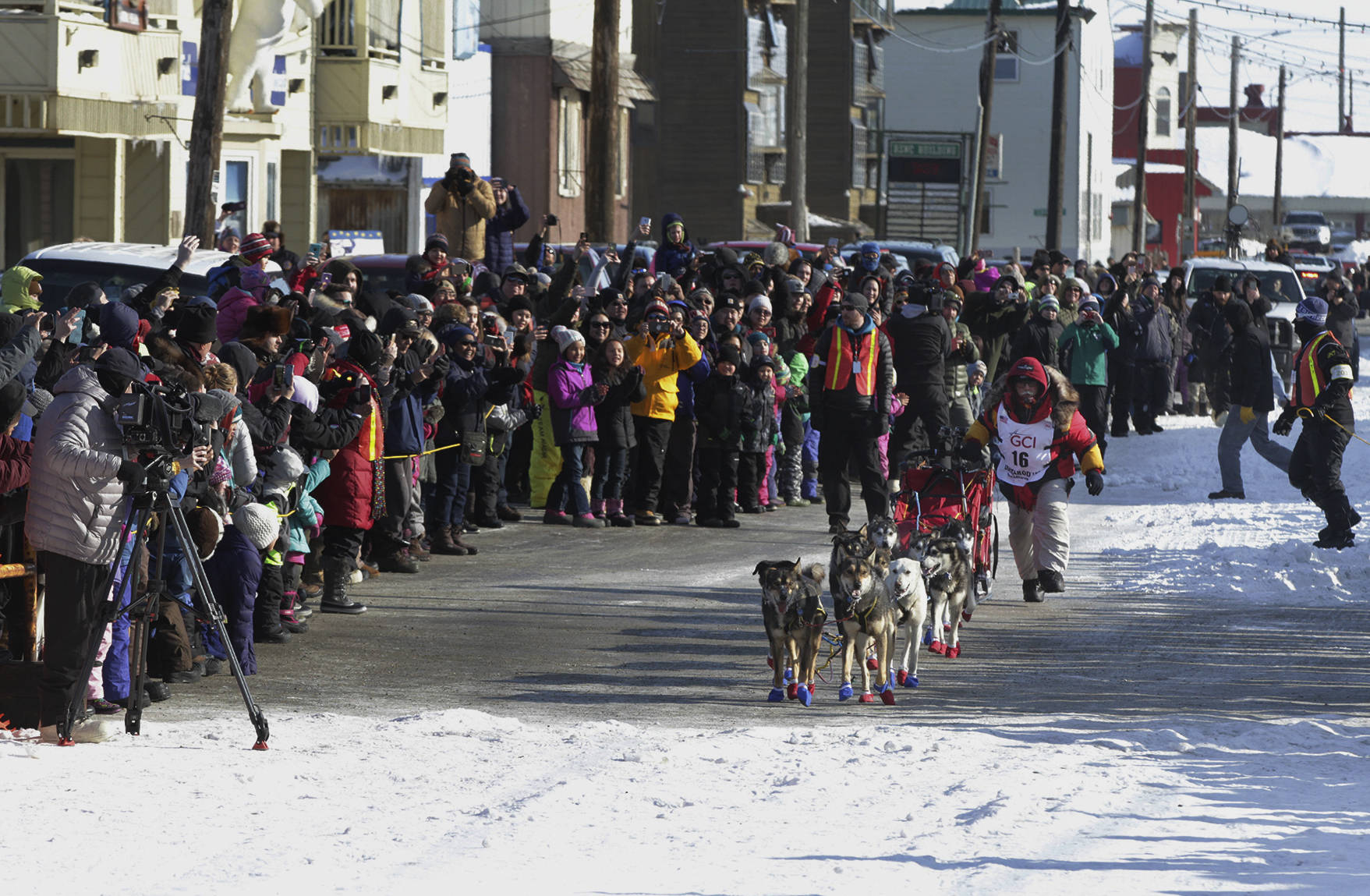 Mitch Seavey, of Sterling, Alaska, runs towards the finish line under the Burled Arch, winning the 1,000-mile Iditarod Trail Sled Dog Race, in Nome, Alaska, Tuesday, March 14, 2017. Seavey won his third Iditarod Trail Sled Dog Race on Tuesday, becoming the fastest and oldest champion at age 57 and helping cement his family’s position as mushing royalty. (AP Photo/Diana Haecker)