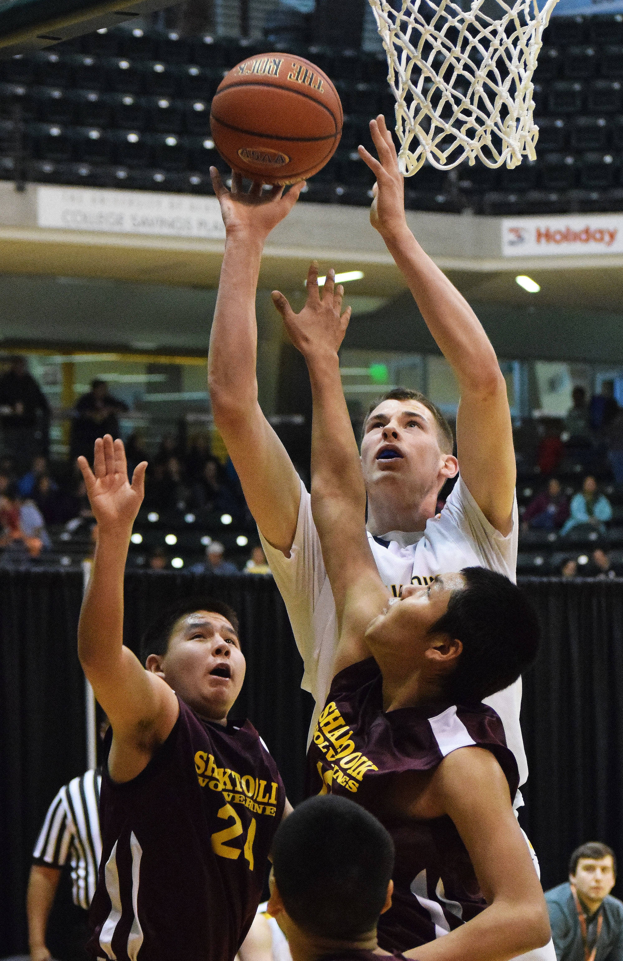 Ninilchik’s Austin White rises above a slew of Shaktoolik defenders Thursday, March 16, 2017, afternoon at the Class 1A state basketball tournament at the Alaska Airlines Center in Anchorage. (Photo by Joey Klecka/Peninsula Clarion)