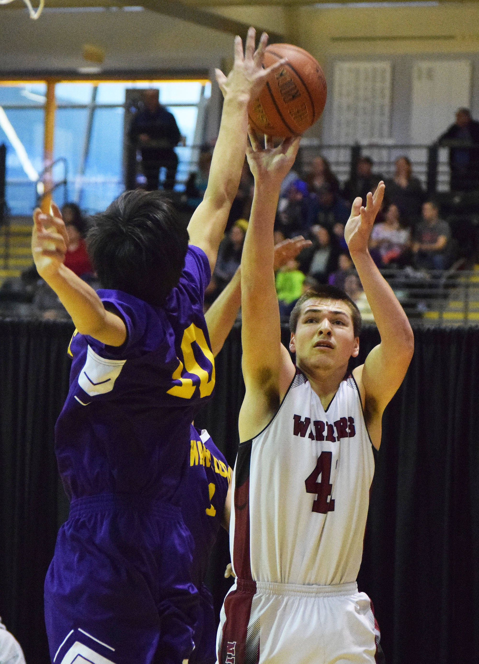 Nikolaevsk’s Michael Trail shoots with Hydaburg defender Mike Eaglestaff blocking Friday, March 17, 2017, at the Class 1A state tournament held at the Alaska Airlines Center in Anchorage. (Photo by Joey Klecka/Peninsula Clarion)