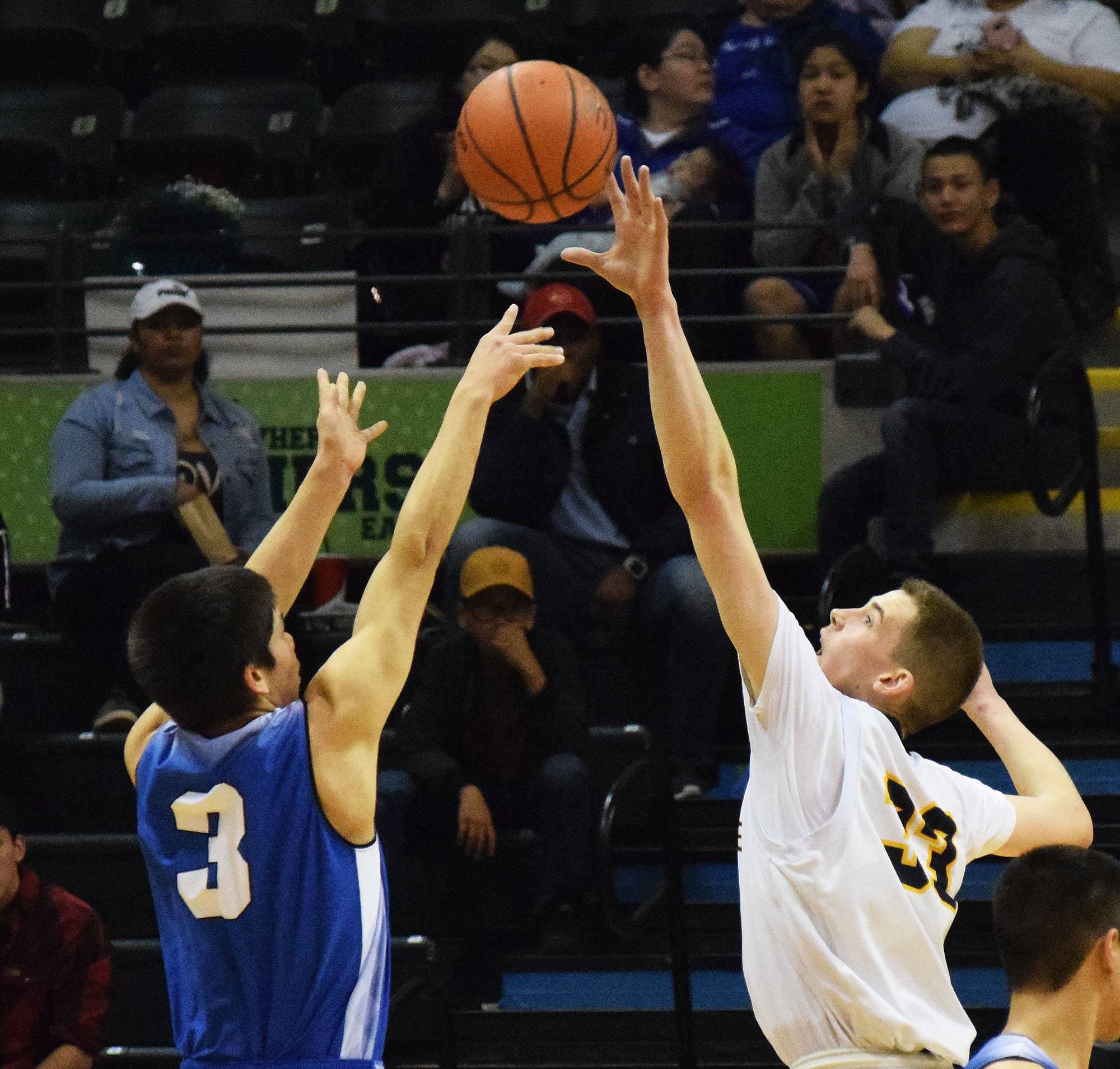 Ninilchik’s Austin White (right) puts a block on Gambell’s Andrew Aningayou in the Class 1A boys state championship Saturday, March 18, 2017, at the Alaska Airlines Center in Anchorage. (Photo by Joey Klecka/Peninsula Clarion)