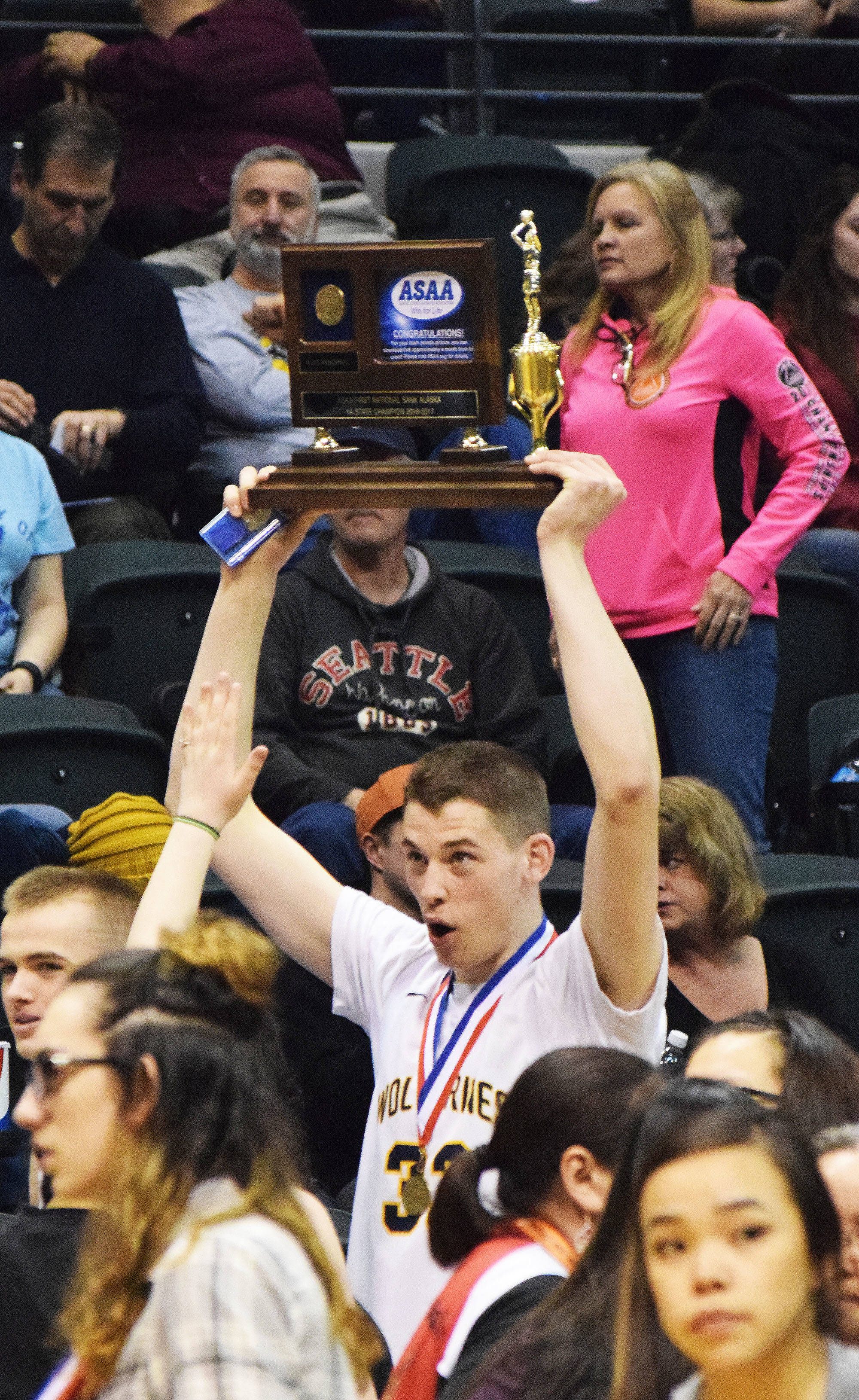 Ninilchik senior Austin White holds the championship trophy high above his head after the Class 1A state championship game Saturday, March 18, 2017, at the Alaska Airlines Center in Anchorage. (Photo by Joey Klecka/Peninsula Clarion)