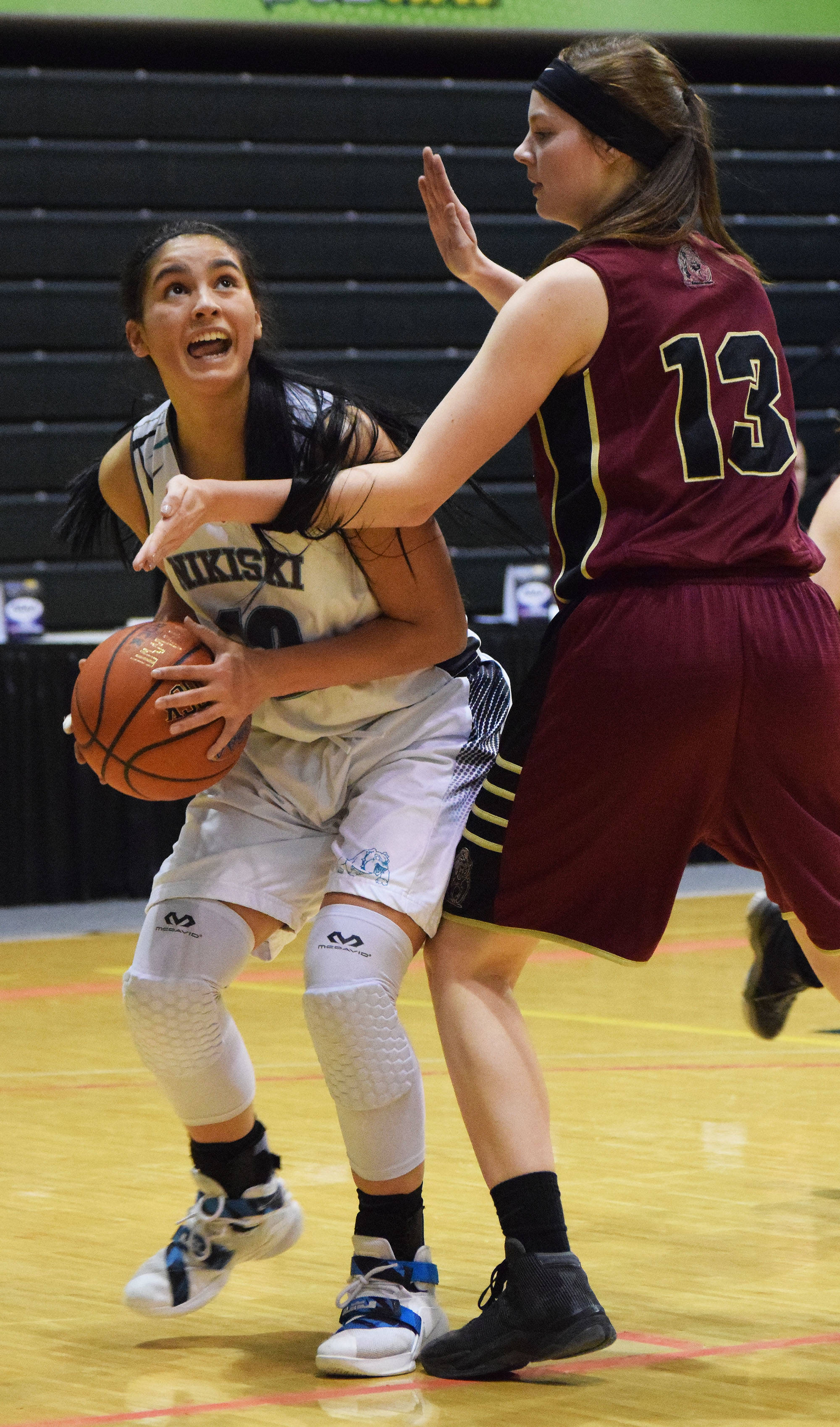 Nikiski’s Brianna Vollertsen (left) looks for a shot against Grace Christian’s Makenna Shamburger in the Class 3A state quarterfinal contest Thursday, March 23, 2017, at the Alaska Airlines Center in Anchorage. (Photo by Joey Klecka/Peninsula Clarion)