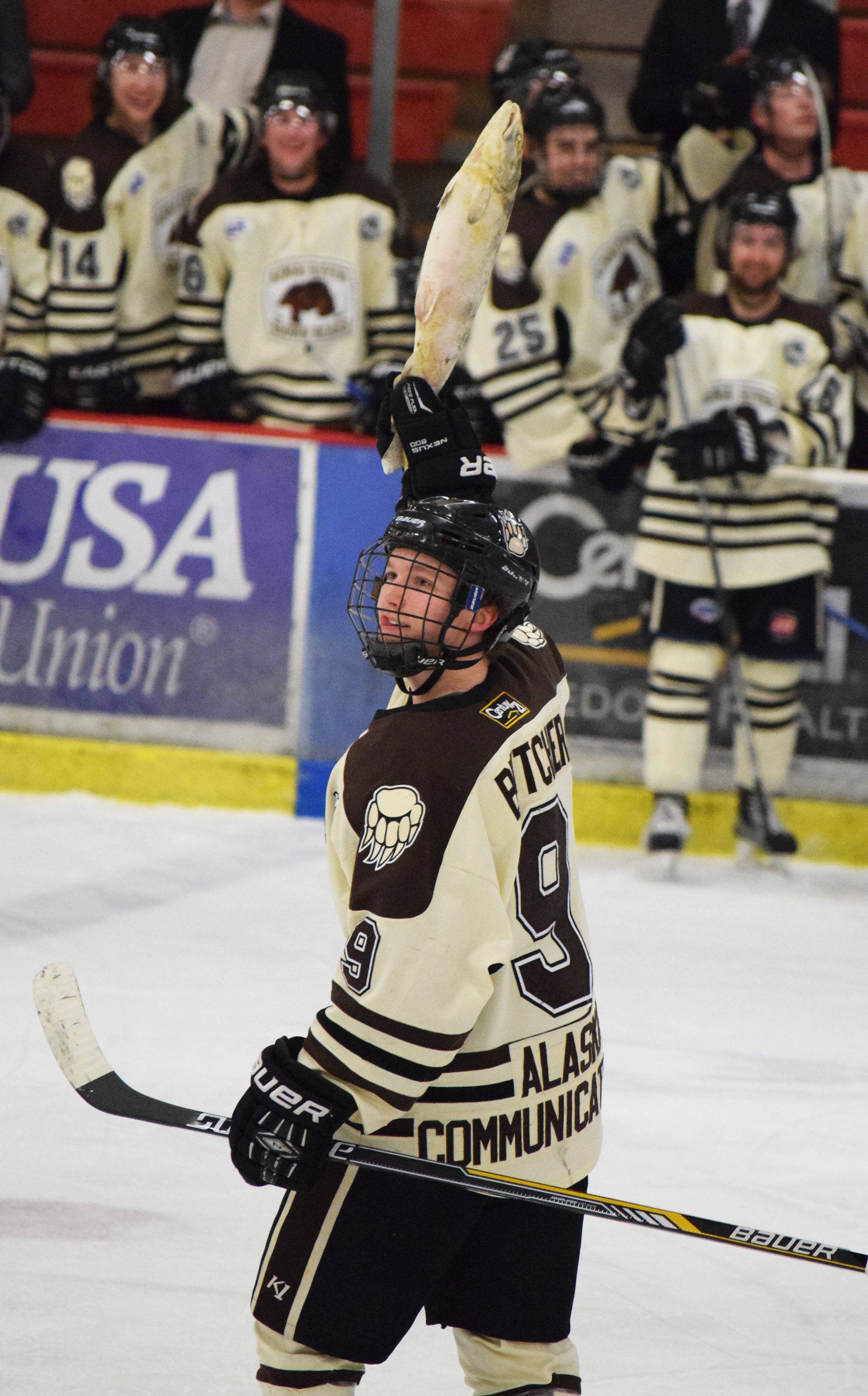 Kenai River’s Evan Butcher hoists up a salmon in a victory salute after the Brown Bears scored the opening goal Saturday night against the Wilkes-Barre/Scranton Knights at the Soldotna Regional Sports Complex.