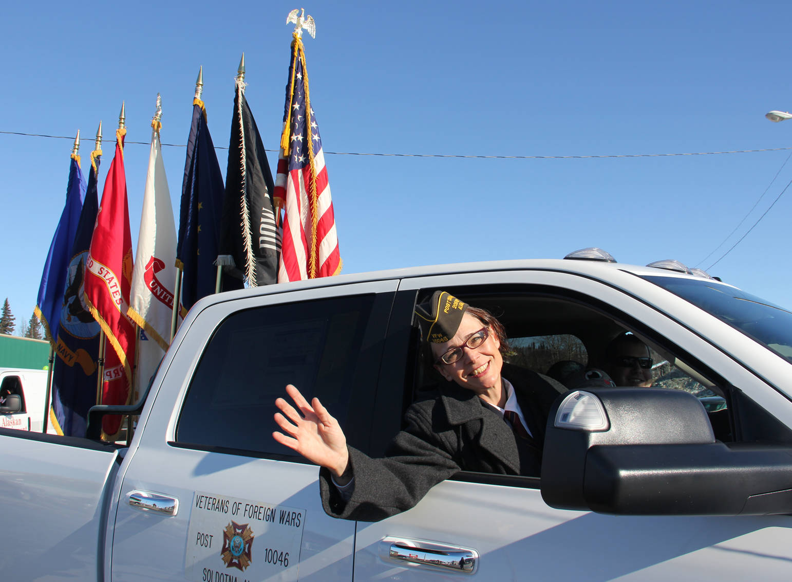VFW Post 10046 commander Anne Toutant waves as Vets parade the Colors.
