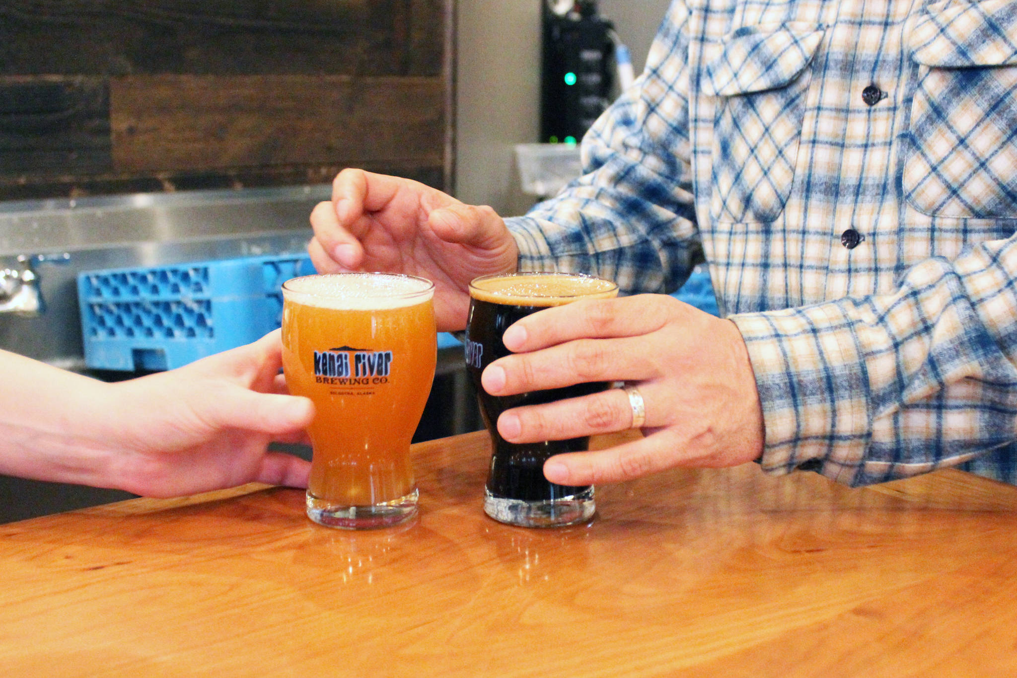 A customer takes his drinks from a bartender Friday, March 31, 2017 at Kenai River Brewing Company in Soldotna, Alaska. Soldotna is one of several communities in the state with establishments opened under public convenience licenses, which would be transitioned to restaurant or eating place licenses under SB 76, a rewrite of Alaska’s alcohol statutes. (Megan Pacer/Peninsula Clarion)