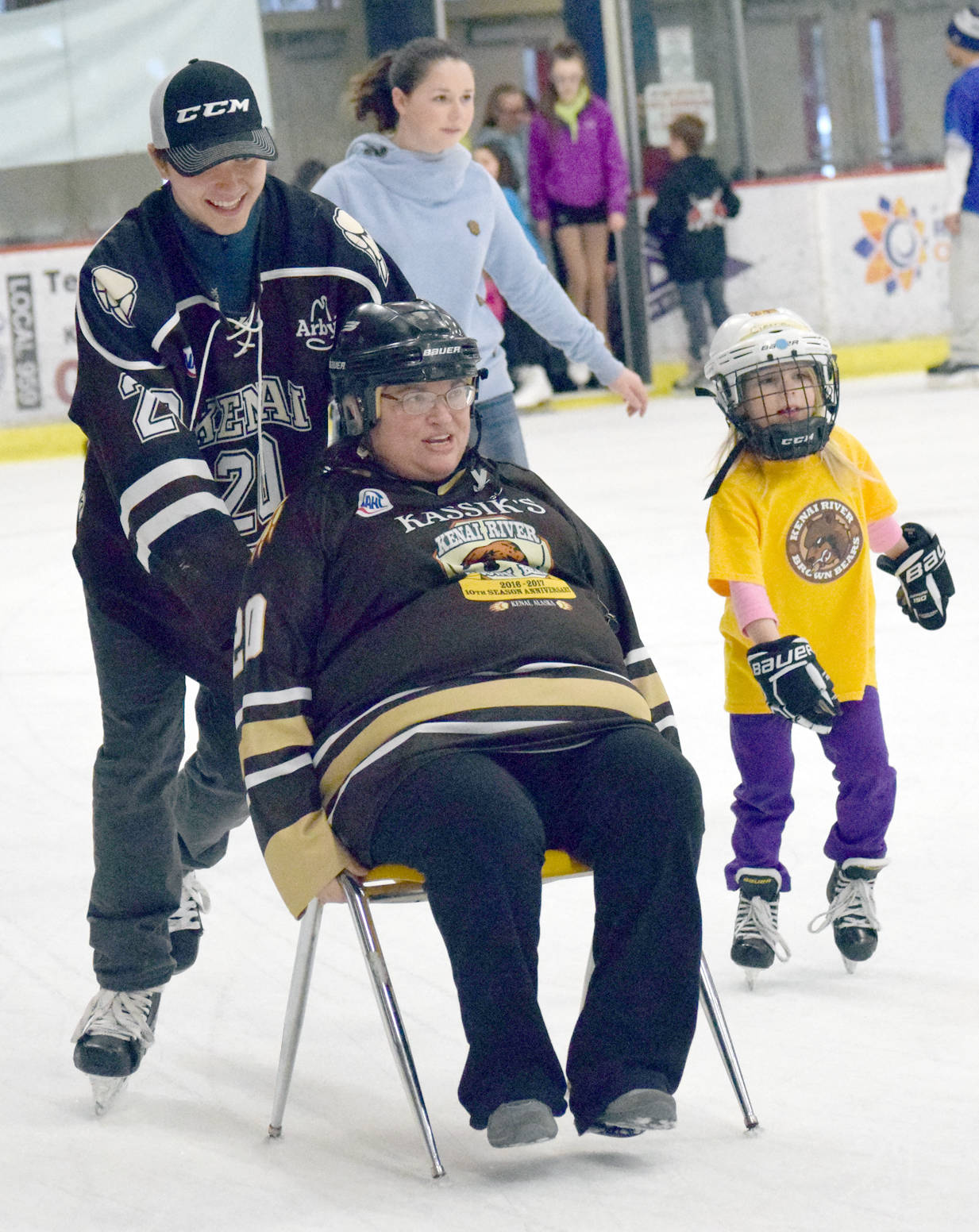 Defenseman Shayne Monahan of the Kenai River Brown Bears pushes Kasilof’s Sandra Berzanske on the ice at the Soldotna Regional Sports Complex during a fundraiser for the team Monday, April 3, 2017. (Photo by Jeff Helminiak/Peninsula Clarion)
