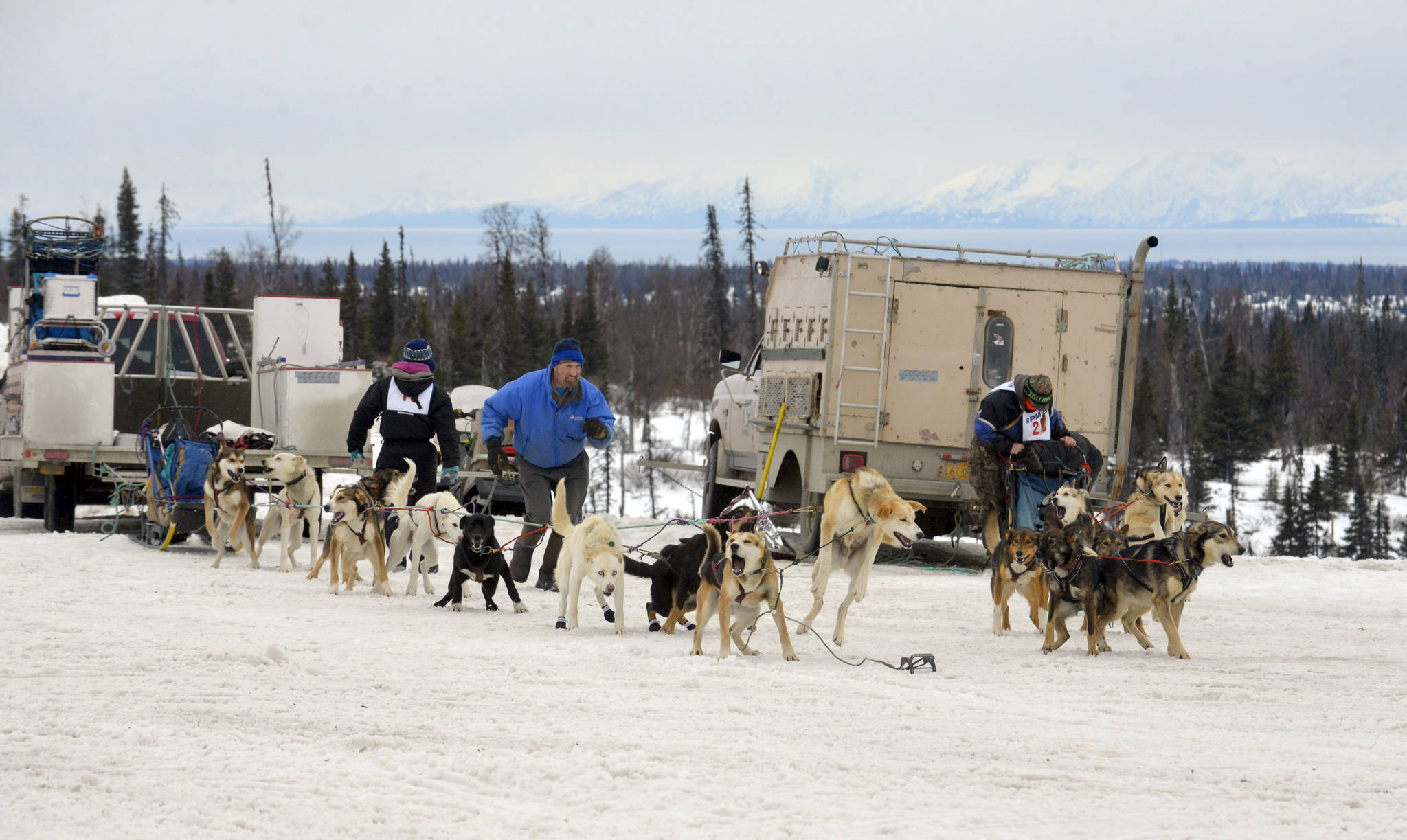 Two teams race to hook up their dogs after the shotgun start at Freddie’s Midnight Run in Caribou Hills on Saturday, April 1. (Kat Sorensen/Peninsula Clarion)