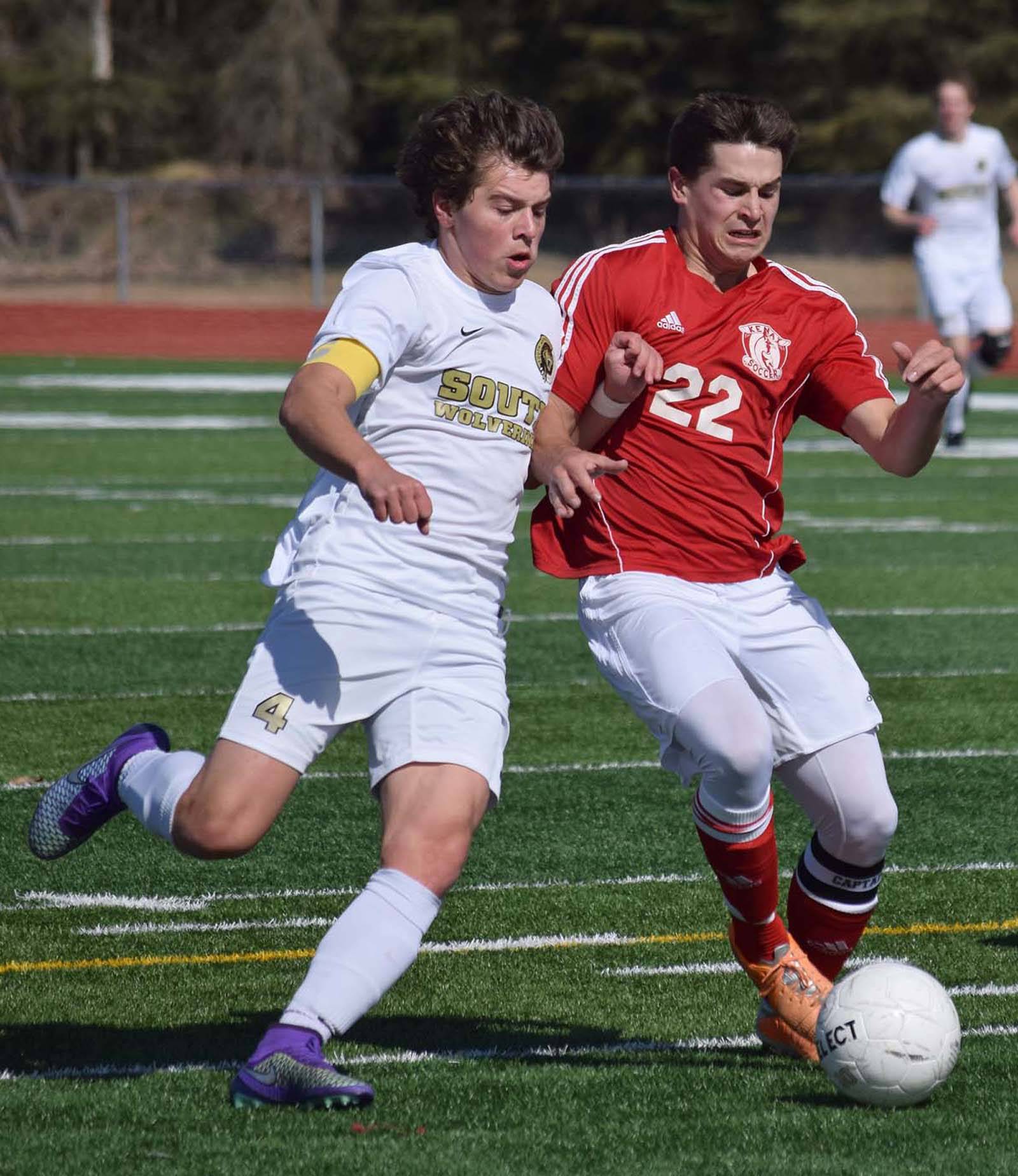 Kenai Central defender Max Dye (22) battles with South Anchorage’s Blake Hepler April 16, 2016, at Ed Hollier Field in Kenai. (Photo by Joey Klecka/Peninsula Clarion)