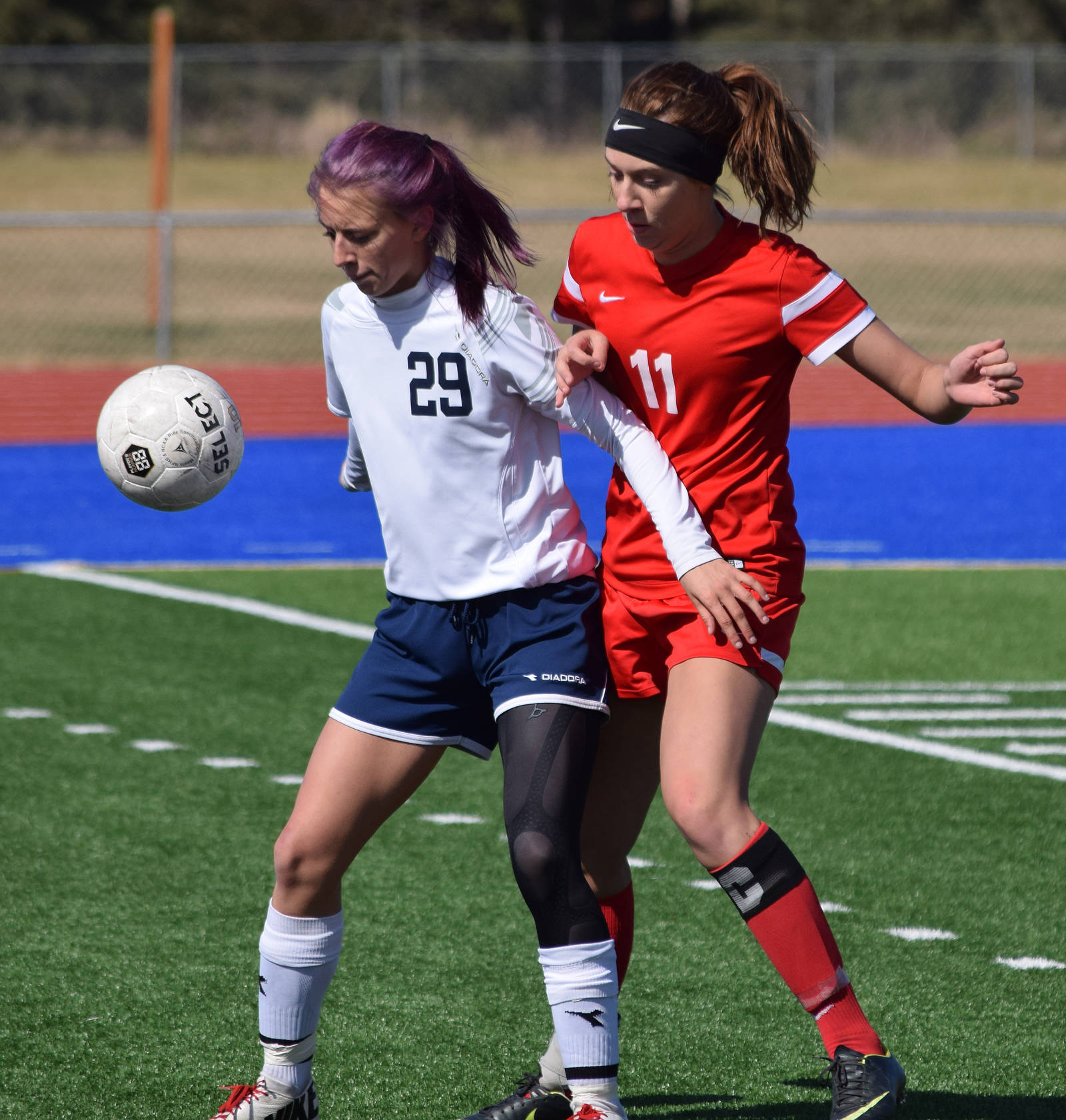 Soldotna’s Abi Tuttle (29) shields Wasilla’s Hayley Brandon from the ball May 7, 2016, at Justin Maile Field in Soldotna. (Photo by Joey Klecka/Peninsula Clarion)