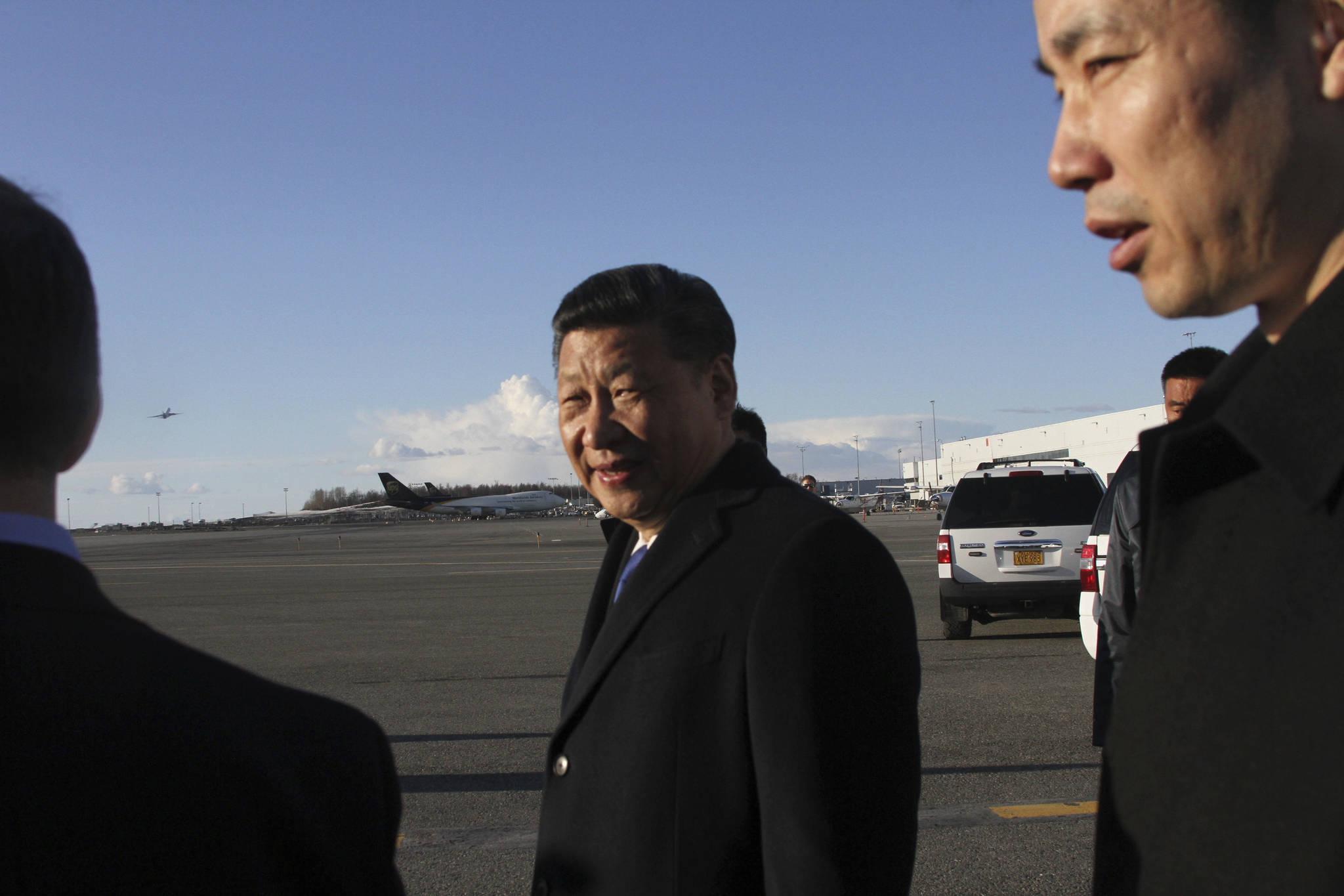 Chinese President Xi Jinping, center, smiles after getting off his plane for a refueling stop in Anchorage, Alaska, on Friday, April 7, 2017. Xi planned a little sightseeing and a meeting and dinner with Alaska Gov. Bill Walker after meeting earlier in the day with President Donald Trump in Florida. (AP Photo/Mark Thiessen)