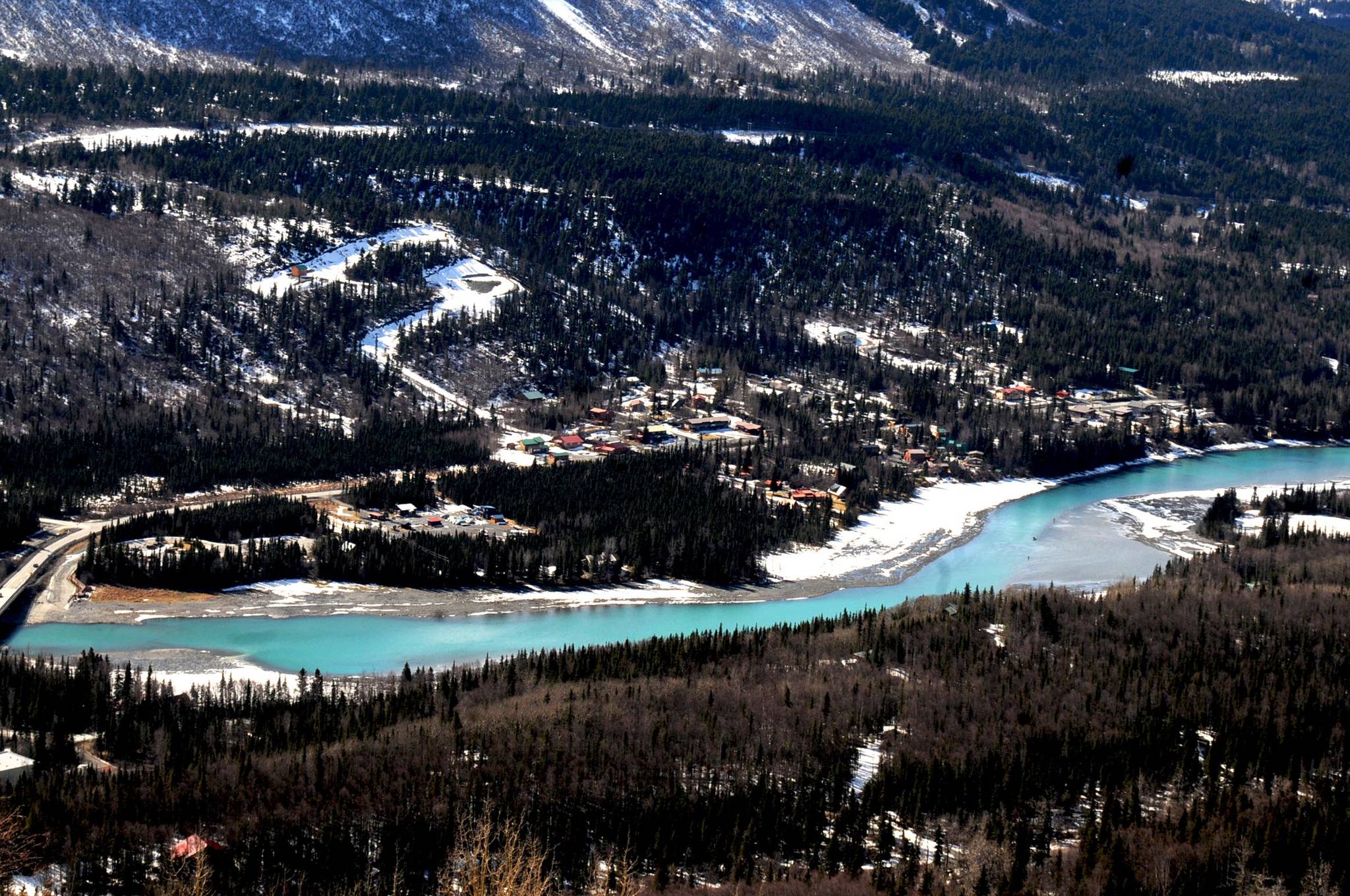 The Kenai River weaves between the Sterling Highway and the mountains on its way to the ocean Saturday, April 8, 2017 in Cooper Landing, Alaska. With bright sunshine and temperatures in the upper 40s and low 50s, the snow began to crack on the hillsides and the river flowed freely between the softening ice of Kenai Lake and Skilak Lake. Anglers couldn’t wait to get in the water — more than a dozen were already parked alongside the highway and tossing lines in the water to see what would bite in April. (Elizabeth Earl/Peninsula Clarion)