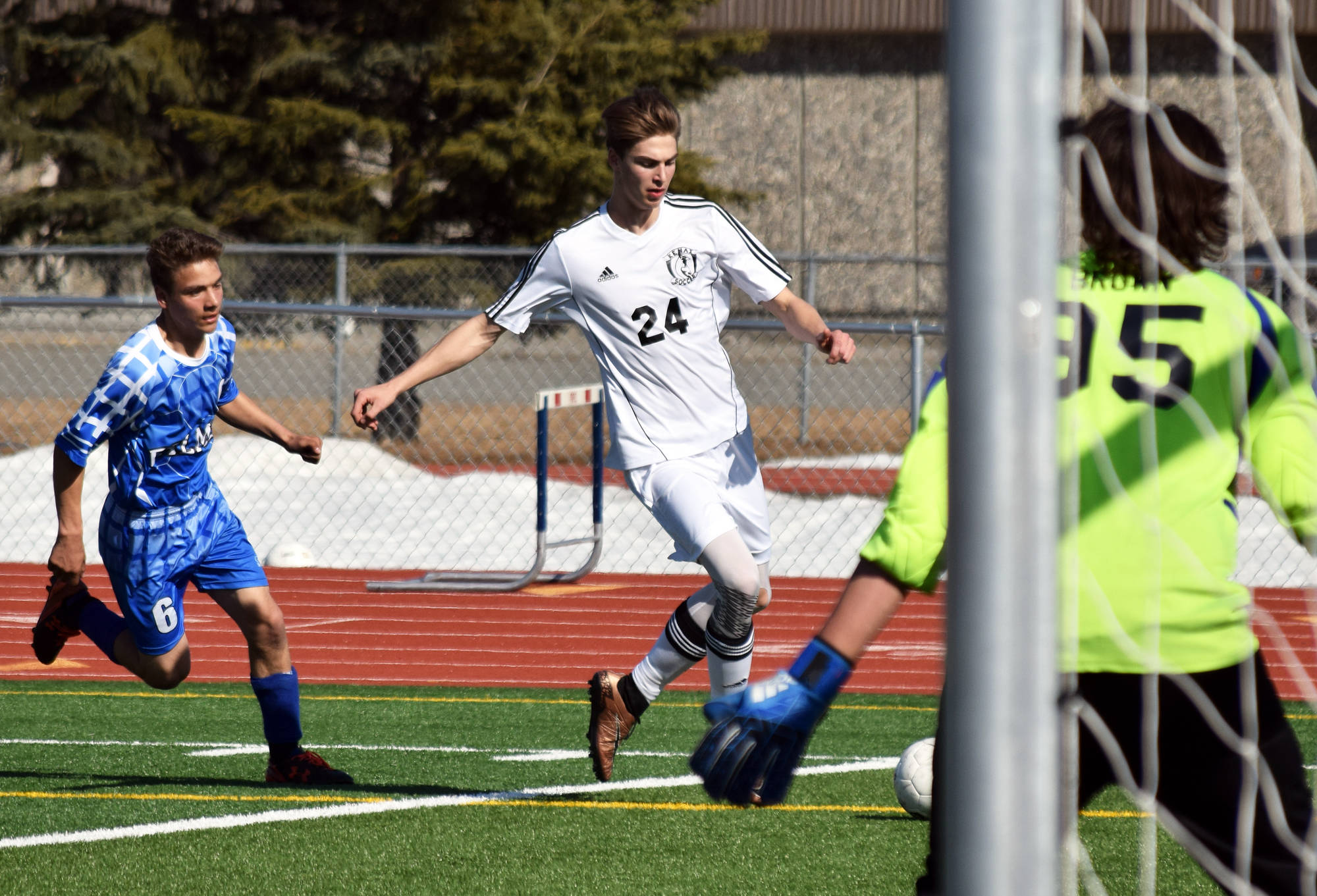 Kenai Central’s Luke Beiser (24) prepares for a shot against Palmer goalie Caden Brown and defender Alex Coyne in Saturday’s contest at Ed Hollier Field in Kenai. (Photo by Joey Klecka/Peninsula Clarion)