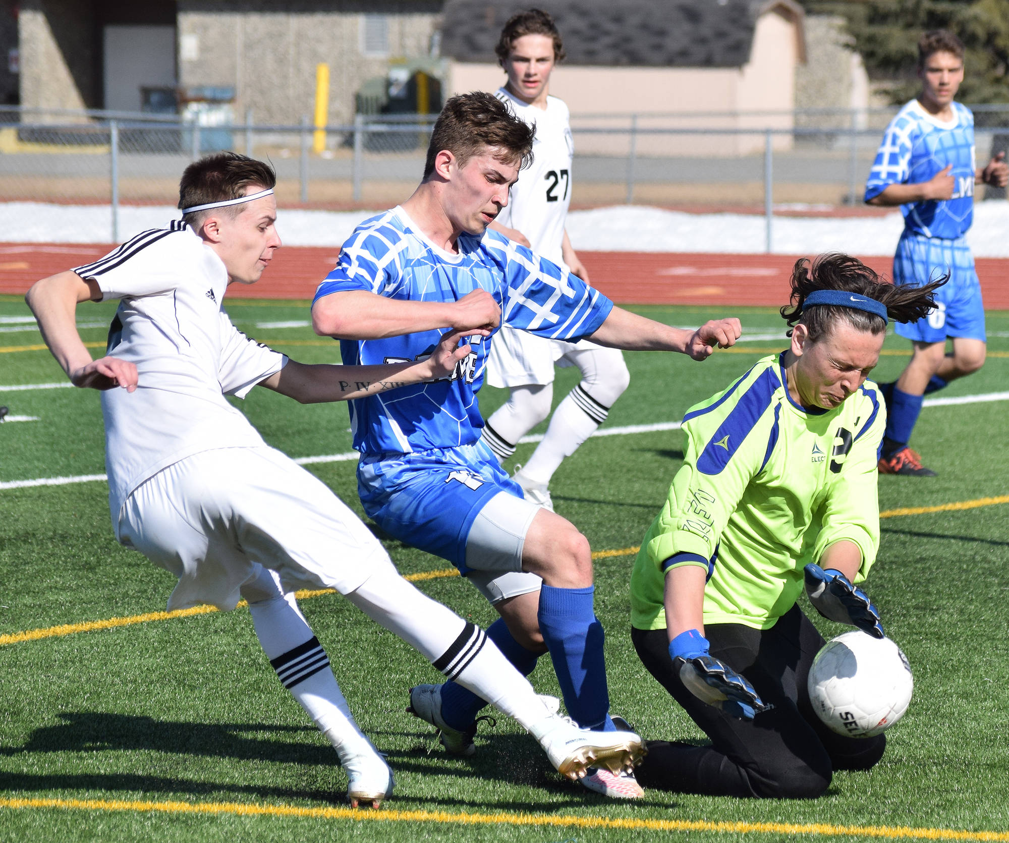Palmer goalkeeper Caden Brown (right) wards off an offensive attack from Kenai Central’s Kalvin Daniels (left) while teammate Makeehan Knittle puts up a block, Saturday at Ed Hollier Field in Kenai. (Photo by Joey Klecka/Peninsula Clarion)
