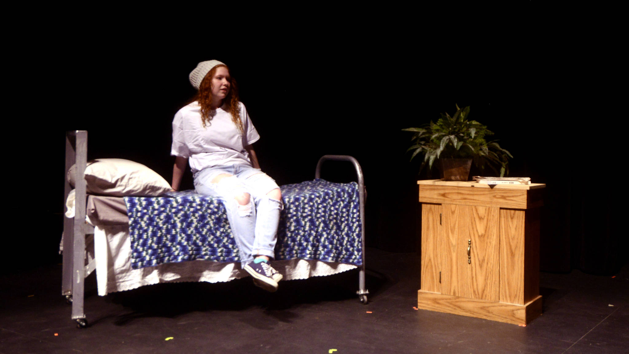 Tehya Nichols performs on stage in the one-act play “HDYMTWBT,” written by Mike Druce, a former Soldotna High School teacher. (Kat Sorensen/Peninsula Clarion)