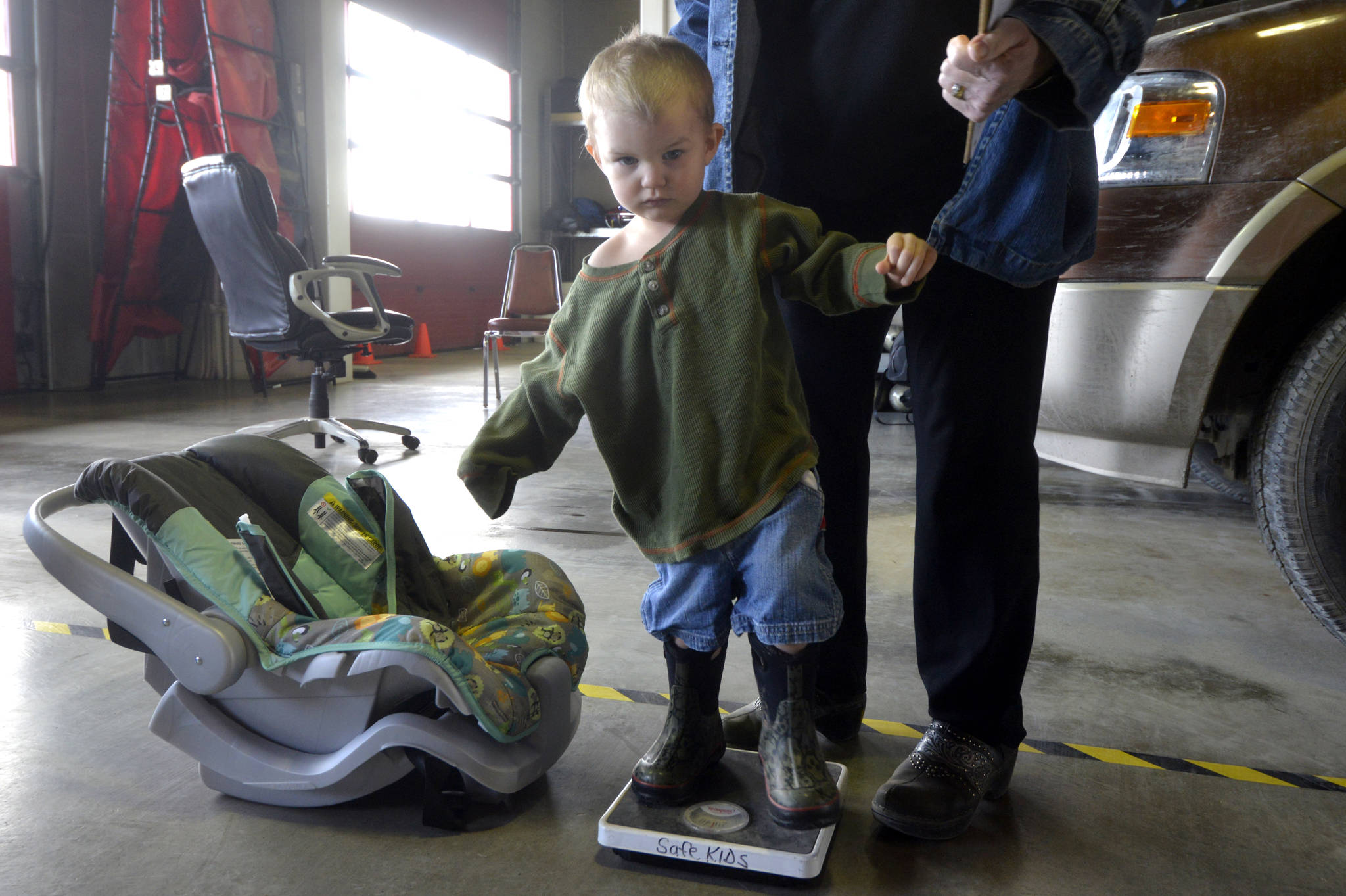 Orion Brandon, a 2-year-old from Sterling, visits the Kenai Fire Station for a free car-seat check up provided by Safe Kids Kenai Peninsula on Monday, April 17, 2017 in Kenai, Alaska. Jane Fellman, of Safe Kids and Central Peninsula Hospital, weighs Brandon to ensure he’s in the right size car seat. Safe Kids is offering another check on Wednesday from 12 to 2 p.m. at the Nikiski Fire Station. (Kat Sorensen/Peninsula Clarion)