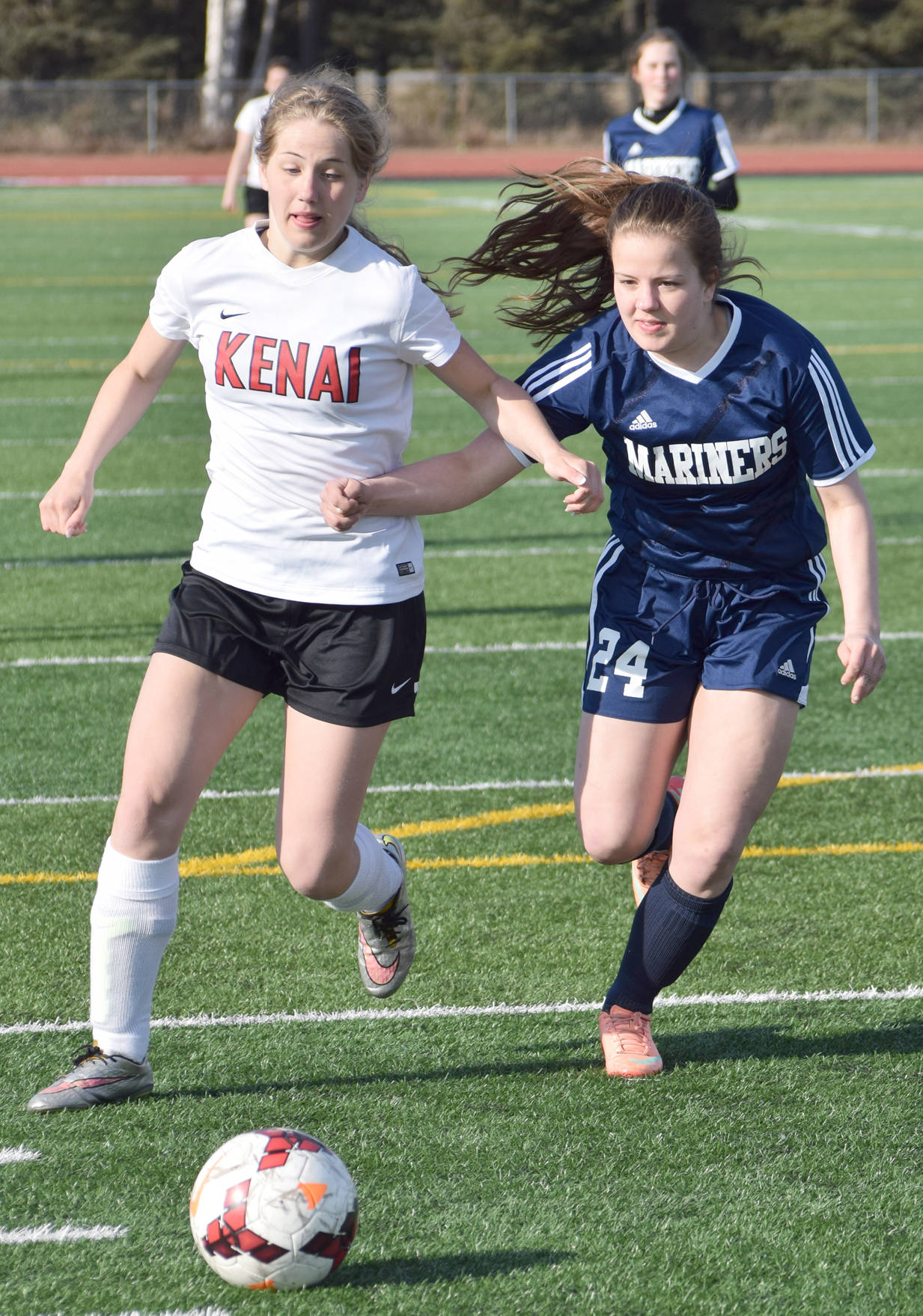 Kenai Central’s Emily Halstead and Homer’s Mychaela Pitta battle for the ball Monday, April 17, 2017, at Kenai Central High School. (Photo by Jeff Helminiak/Peninsula Clarion)