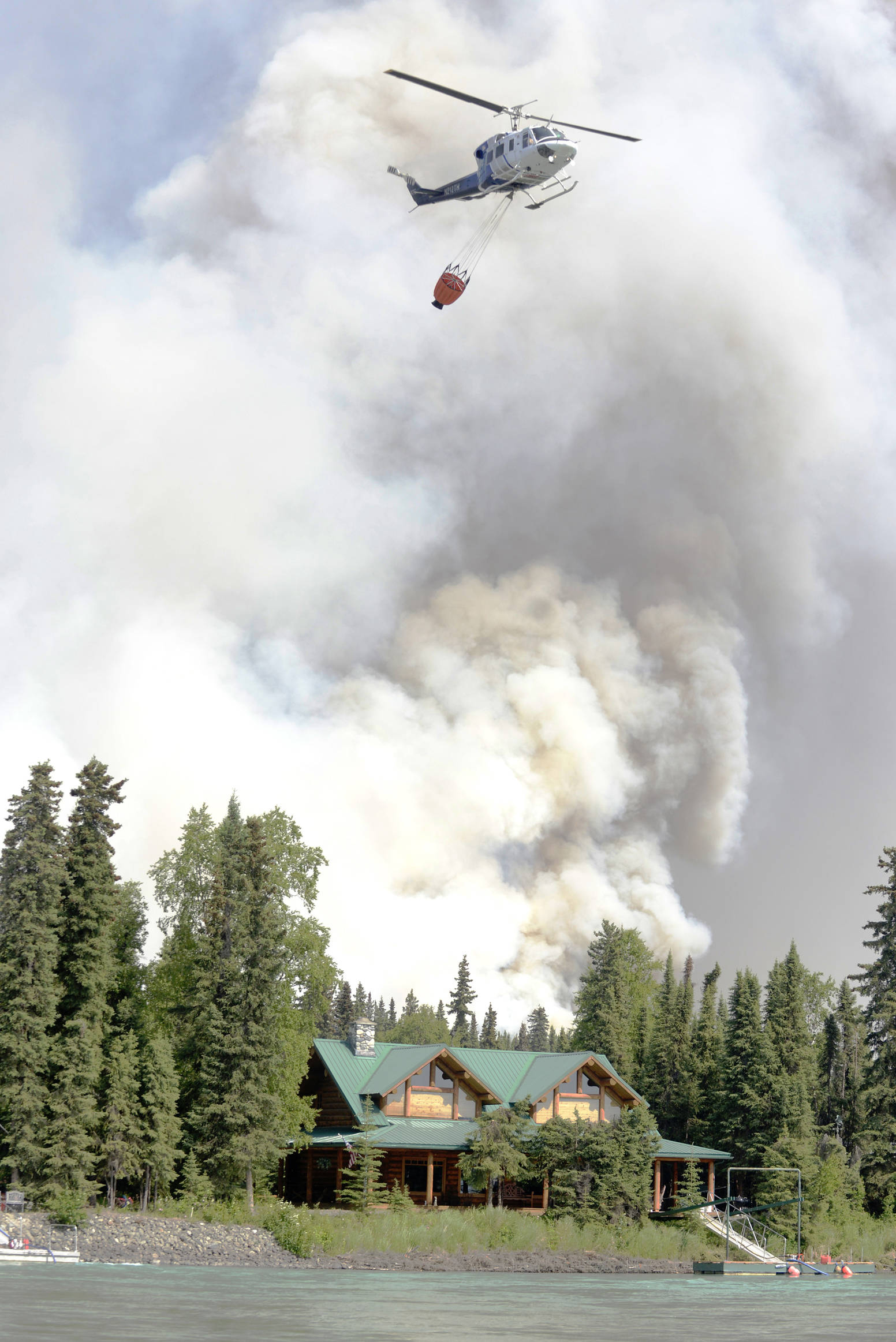 A helicopter returns from a dumping run on the north shore of the Kenai River during the Card Street wildfire in this June 16, 2015 photo. (Ben Boettger/Peninsula Clarion, file)