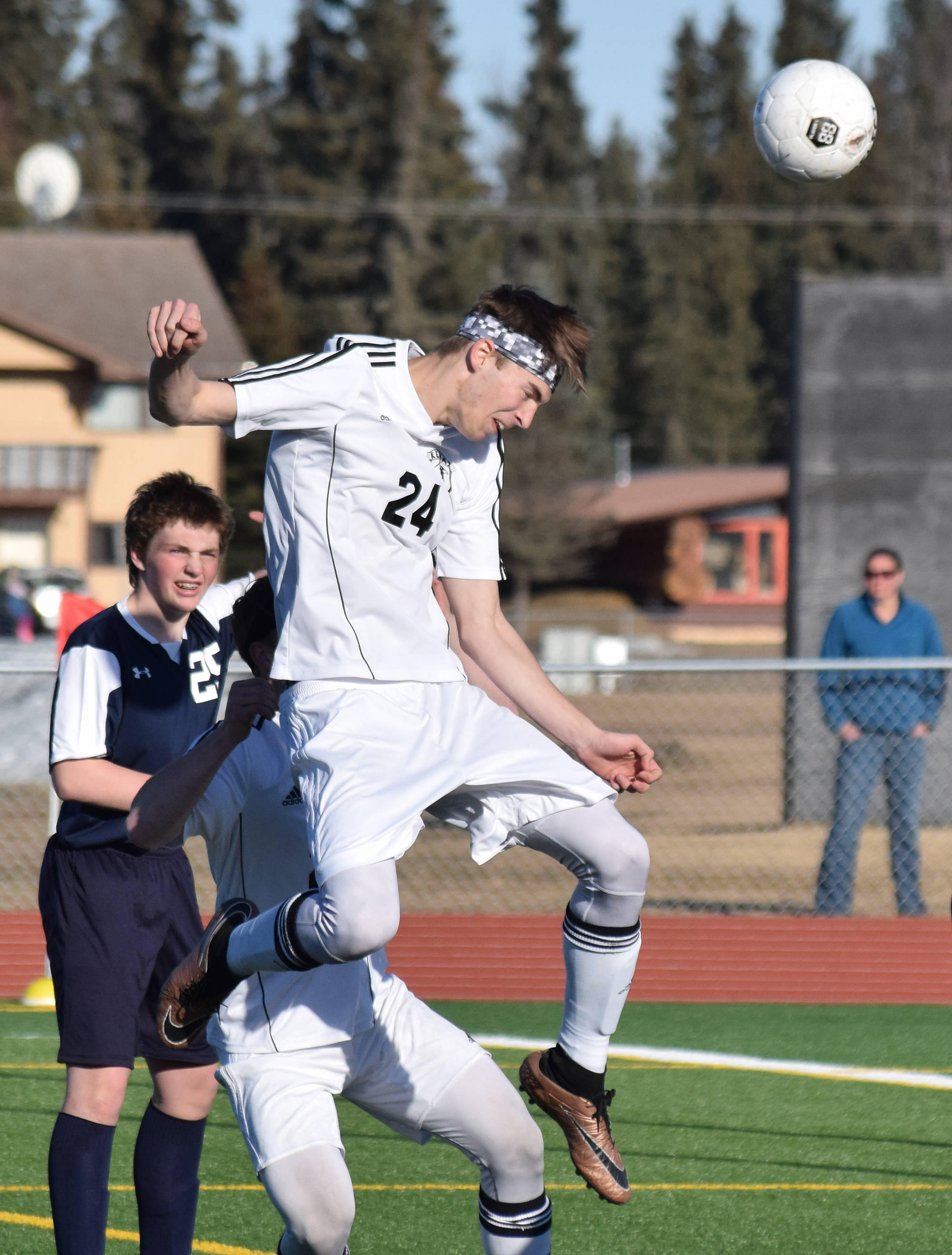 Kenai Central’s Luke Beiser (24) heads a ball towards the Soldotna net early in Tuesday’s conference game at Ed Hollier Field in Kenai. (Photo by Joey Klecka/Peninsula Clarion)