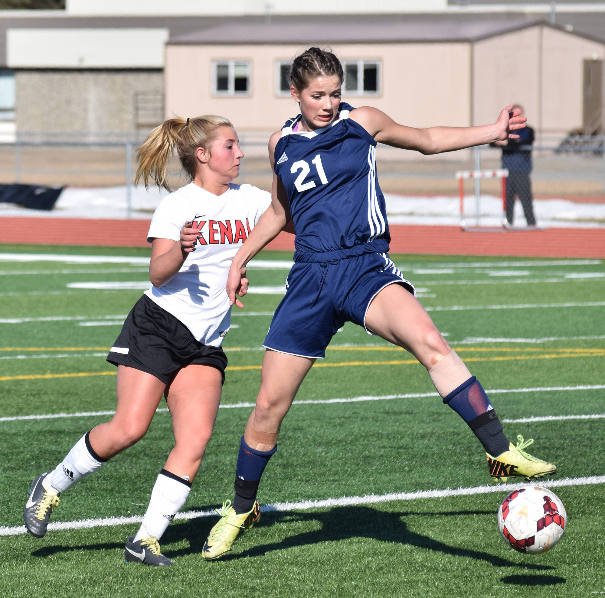 Soldotna’s Ella Stenga (21) works to keep the ball away from Kenai Central’s Annebelle Schneiders in a conference matchup Tuesday afternoon at Ed Hollier Field in Kenai. (Photo by Joey Klecka/Peninsula Clarion)