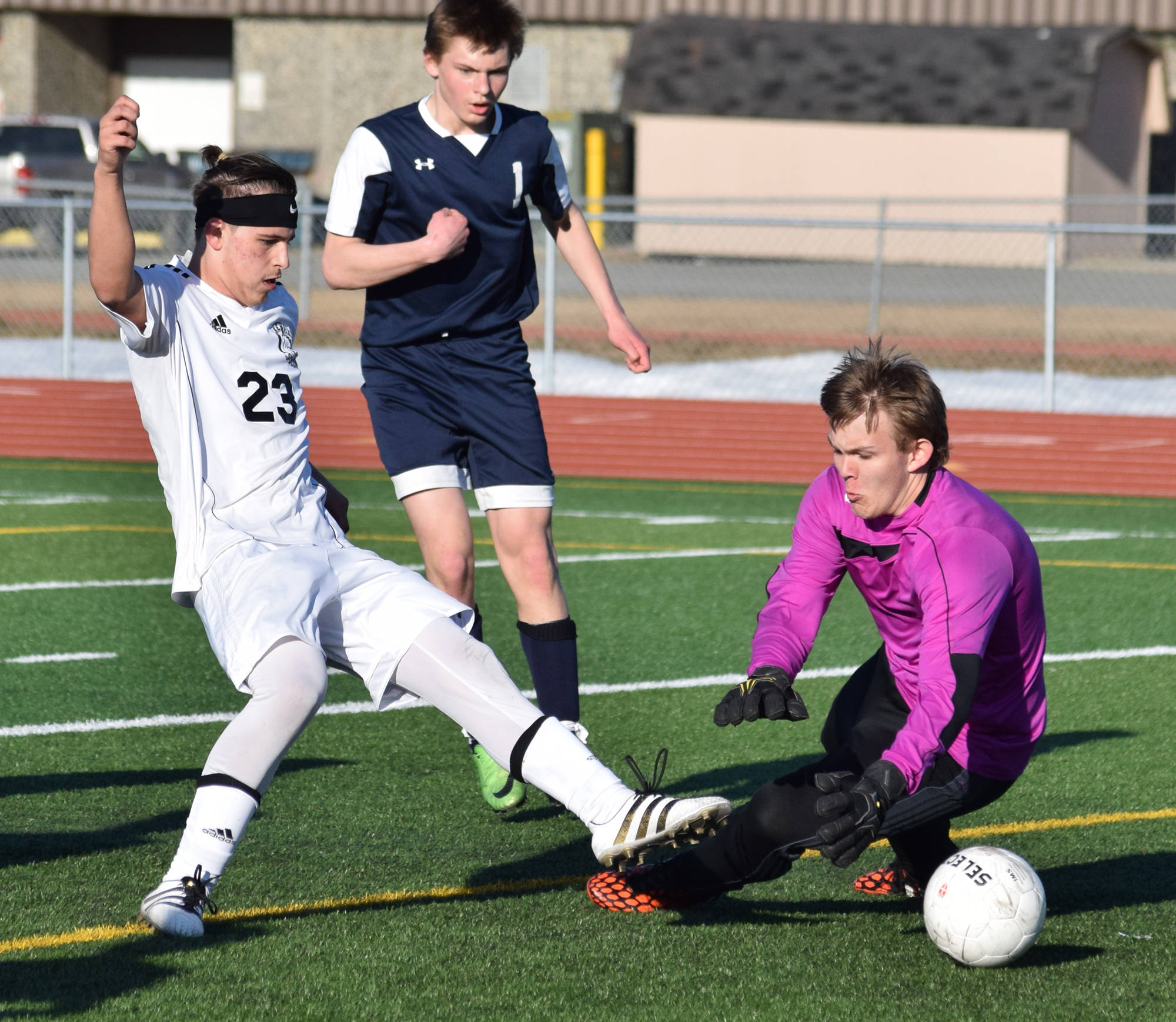 Kenai Central’s Zack Tuttle slots a goal past Soldotna goalkeeper Chase Miller in Tuesday’s conference game at Ed Hollier Field in Kenai. (Photo by Joey Klecka/Peninsula Clarion)