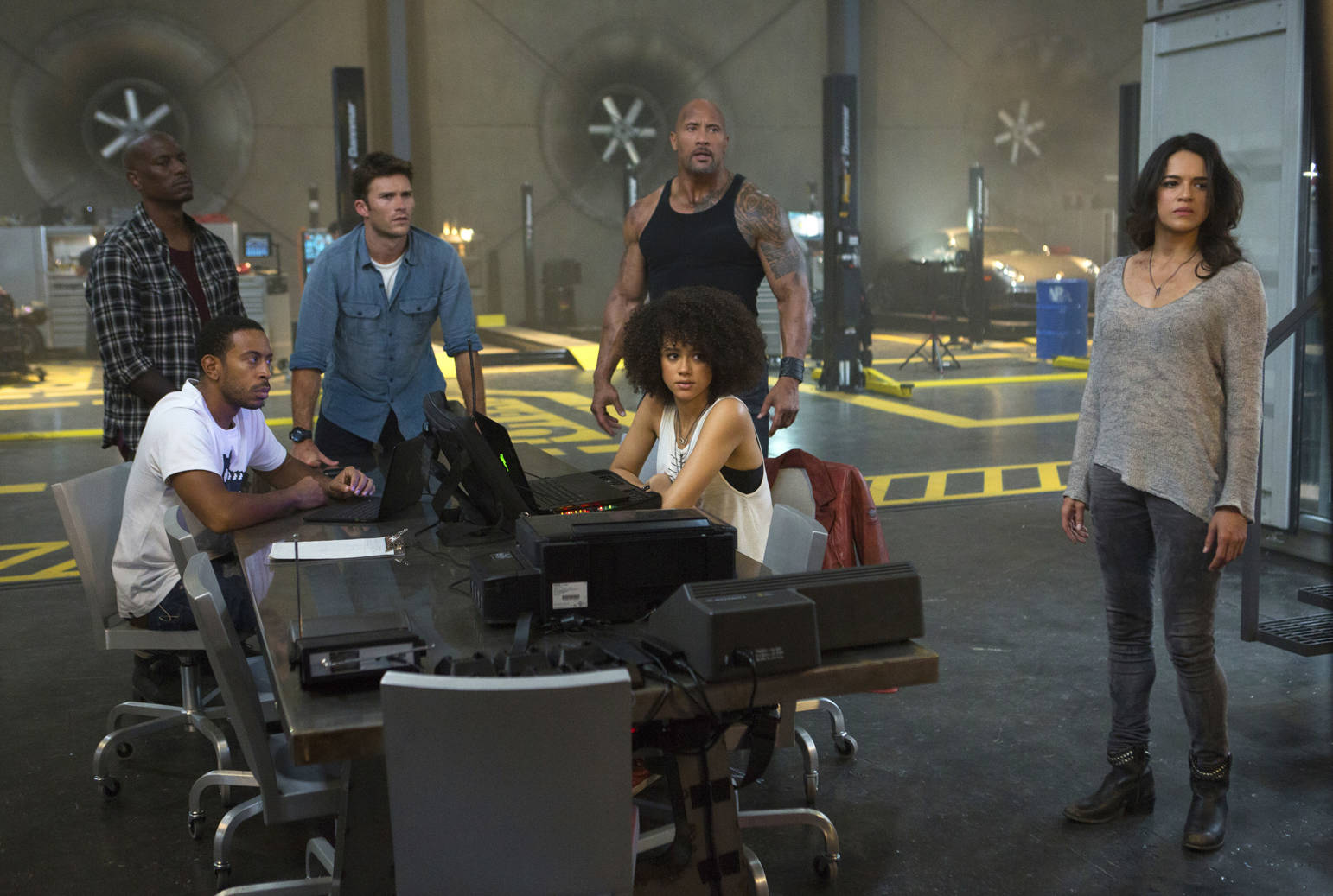 This image released by Universal Pictures shows, Chris “Ludacris” Bridges, seated left, and Nathalie Emmanuel, seated right, and Tyrese Gibson, standing from left, Scott Eastwood, Dwayne Johnson and Michelle Rodriguez in “The Fate of the Furious.” (Matt Kennedy/Universal Pictures via AP)