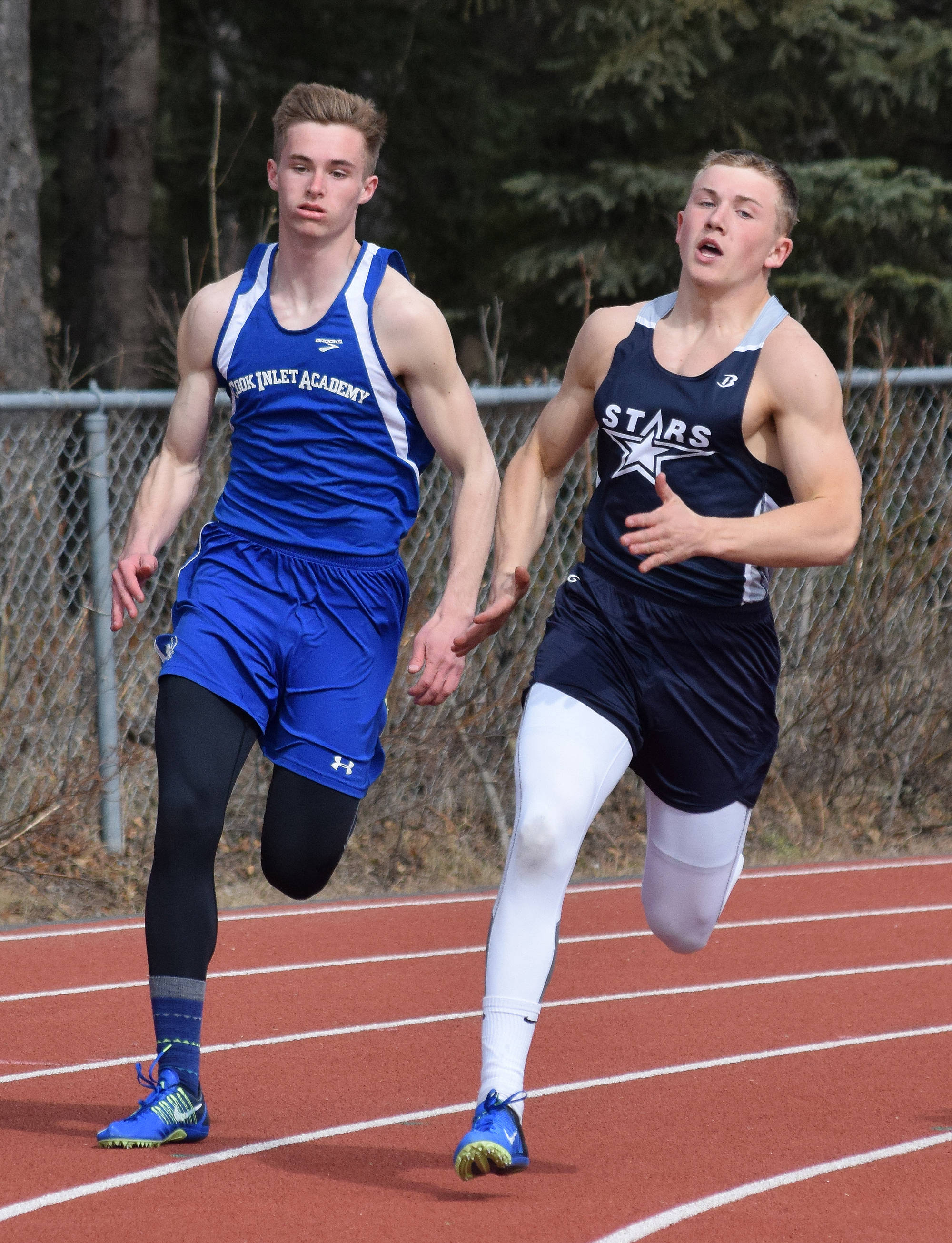 Cook Inlet Academy’s Noah Leaf (left) races Soldotna’s Brenner Furlong in Saturday’s boys 200-meter sprint at the Kenai Invitational at Ed Hollier Field in Kenai. (Photo by Joey Klecka/Peninsula Clarion)