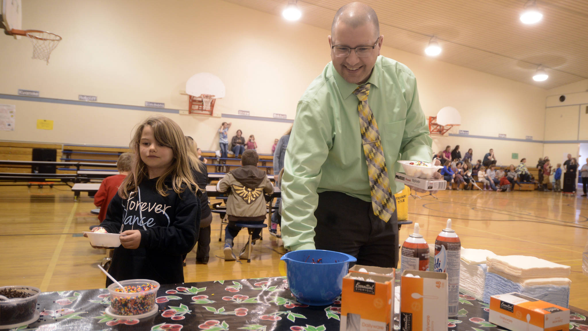 First-grader Shea Linton, left, joined Soldotna Montessori Charter School’s new principal John DeVolld at an ice cream social event on Tuesday night at the school. The event was organized by the school’s PTO to welcome DeVolld as the new principal for the upcoming school year. (Kat Sorensen/Peninsula Clarion)