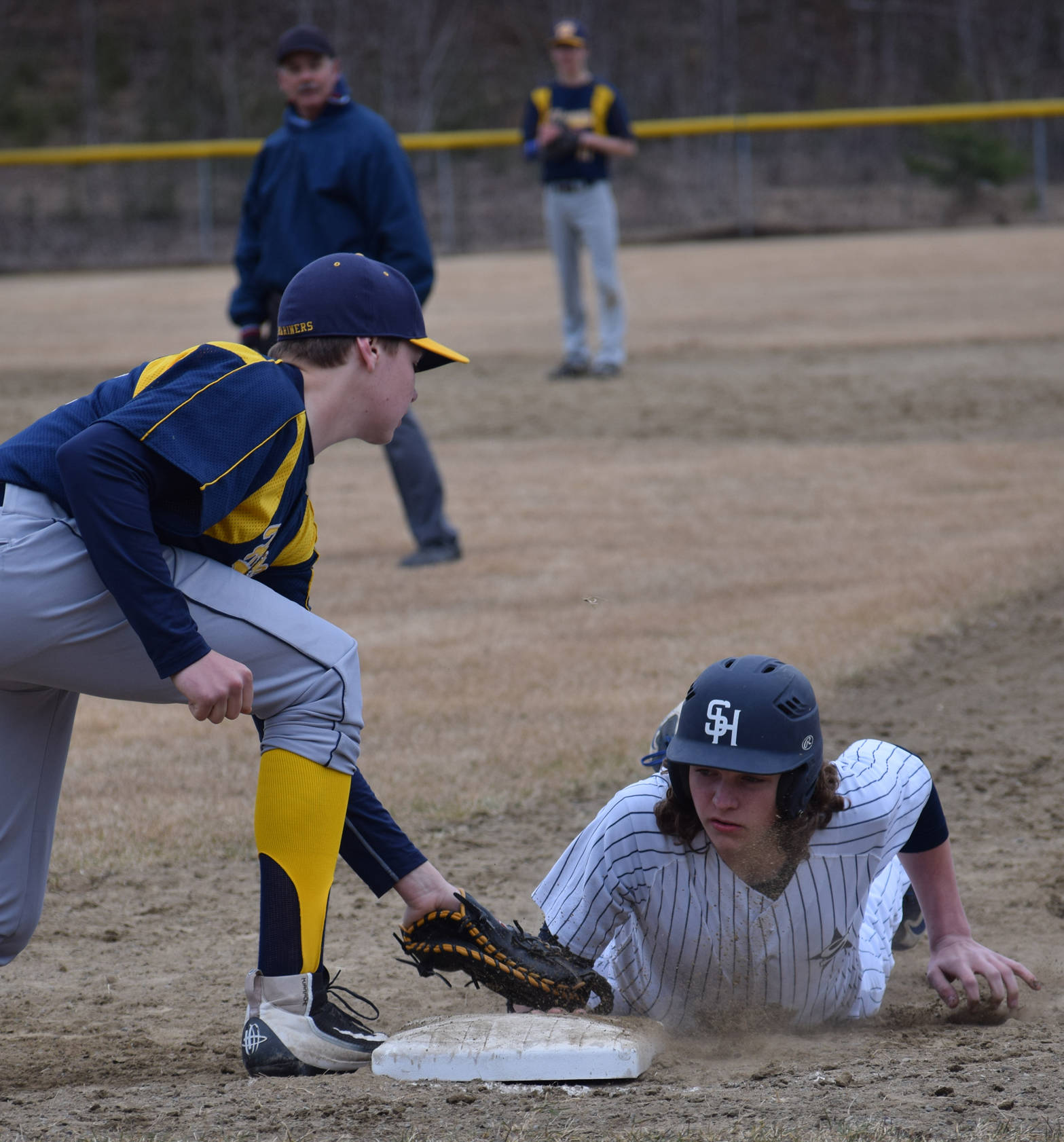 Soldotna’s Logan Smith slides under the tag of Homer’s Adam Brinster on Tuesday at the Soldotna Little League fields. (Photo by Jeff Helminiak/Peninsula Clarion)