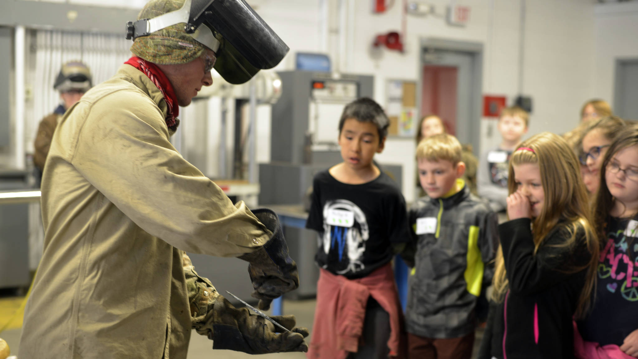 Connor McKamy, a graduate of the Kenai Peninsula College’s welding program, shows fourth-graders from Mountain View Elementary an example of the work he does. (Kat Sorensen/Peninsula Clarion)