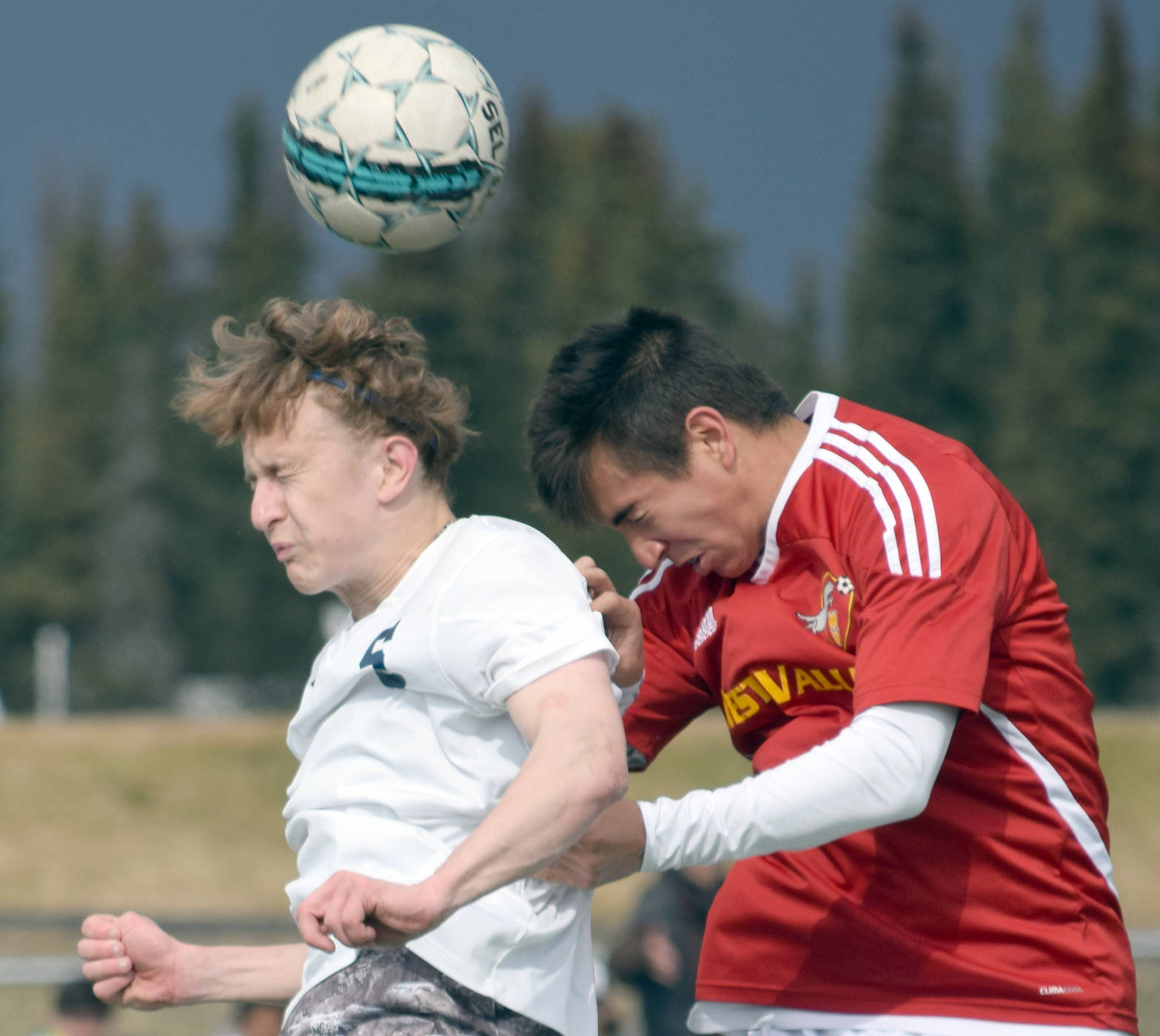 Soldotna’s Luke Trammell and West Valley’s Drew Rizk battle in the air Wednesday, April 28, 2017, at Soldotna High School. (Photo by Jeff Helminiak/Peninsula Clarion)