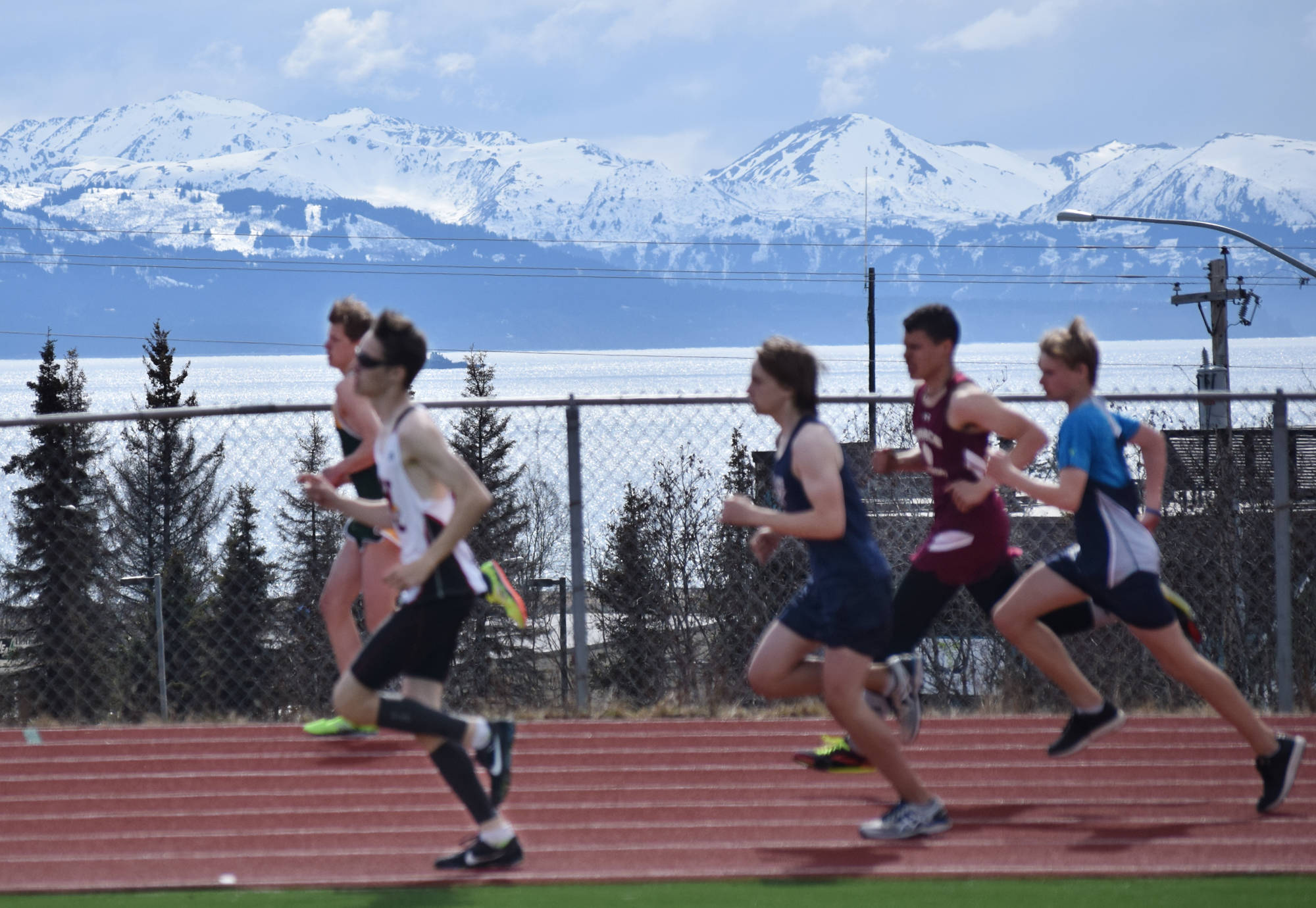 A group of boys race by a dazzling view of Kachemak Bay, Saturday at the Homer Invite at Homer High School. (Photo by Joey Klecka/Peninsula Clarion)