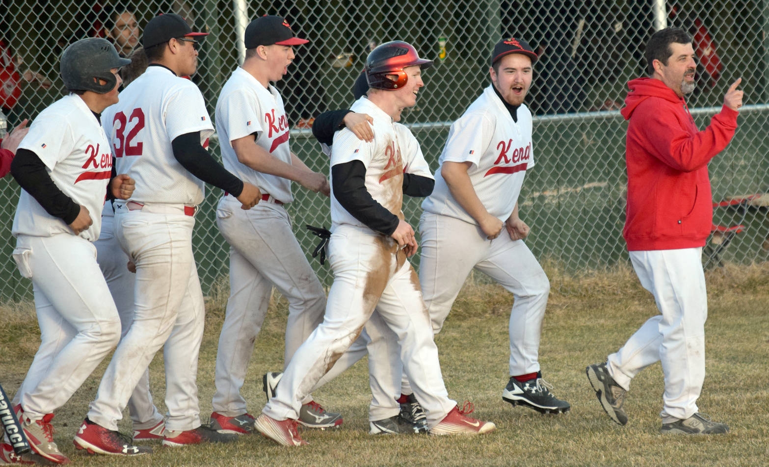 Kenai Central celebrates after Paul Steffensen (center, red-striped batting helmet) had a walk-off steal of home to defeat Kodiak 13-12 in eight innings Wednesday, May 3, 2017, at the Kenai Little League fields. (Photo by Jeff Helminiak/Peninsula Clarion)