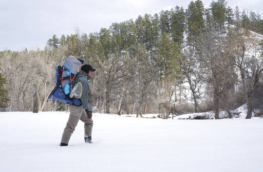 In this January 2017 photo, Josh Peterson carries his daughter, Miriam, to fish at Sand Creek in northeast Wyoming. (Christene Peterson /The Casper Star-Tribune via AP)