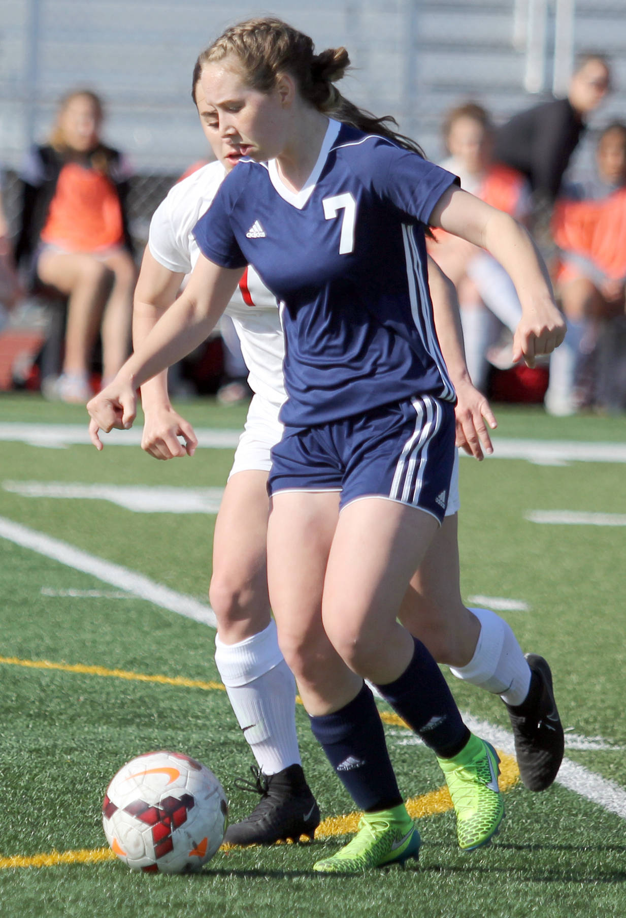 Soldotna’s Journey Miller works the ball past Wasilla freshman Reese Sande in the midfield during a 7-0 loss to the Warriors on Friday evening at Wasilla High School. (Photo by Jeremiah Bartz/Frontiersman.com)