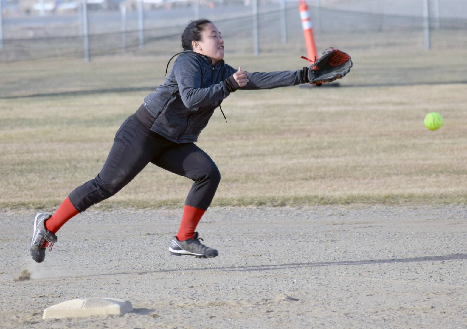 A single by Soldotna’s Carlin Meyer lands just out of the reach of Kenai Central shortstop Patricia Catacutan on Friday, May 5, 2017, at Steve Shearer Memorial Ball Park in Kenai. (Photo by Jeff Helminiak/Peninsula Clarion)